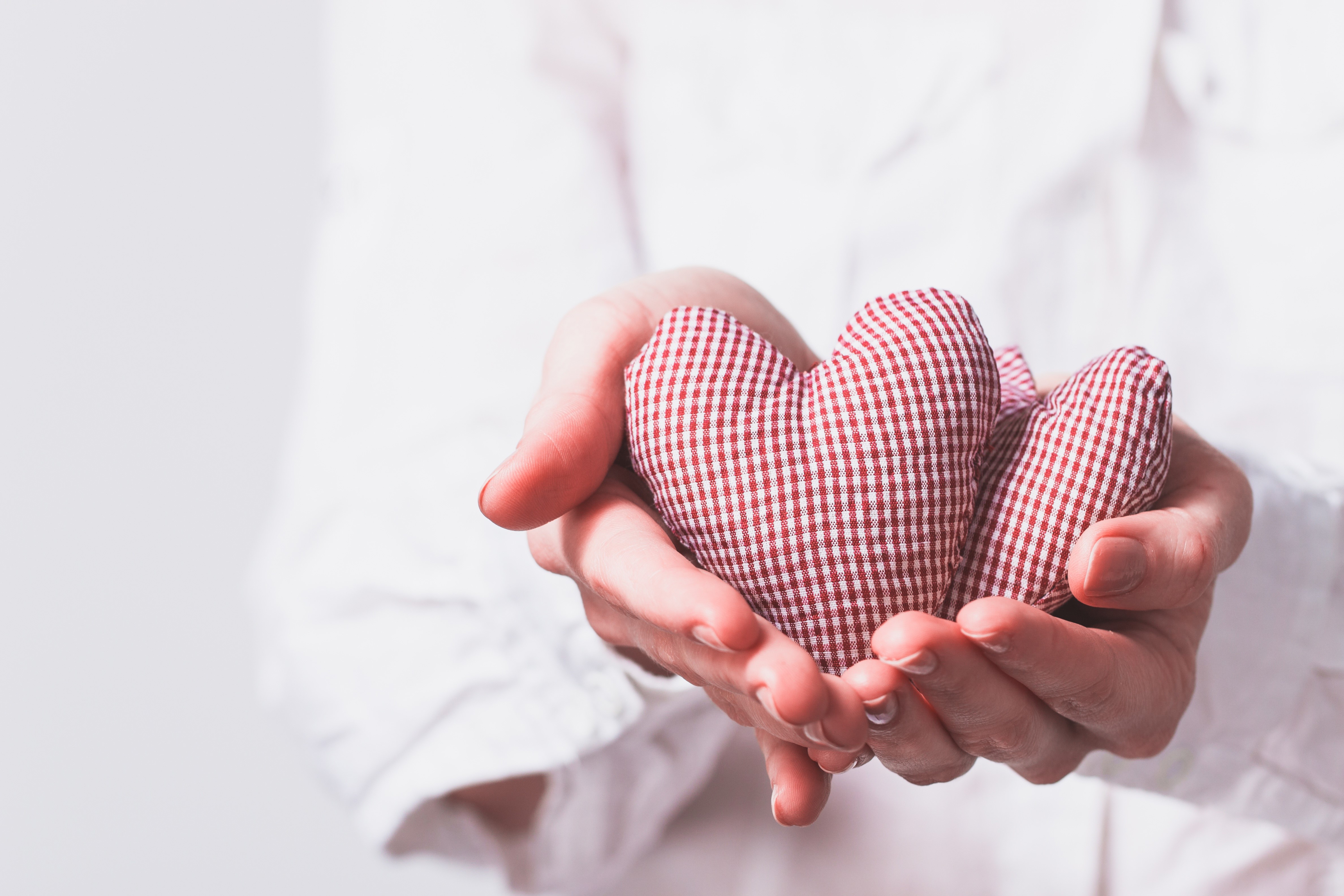 Hands holding two checkered hearts HD Wallpaper