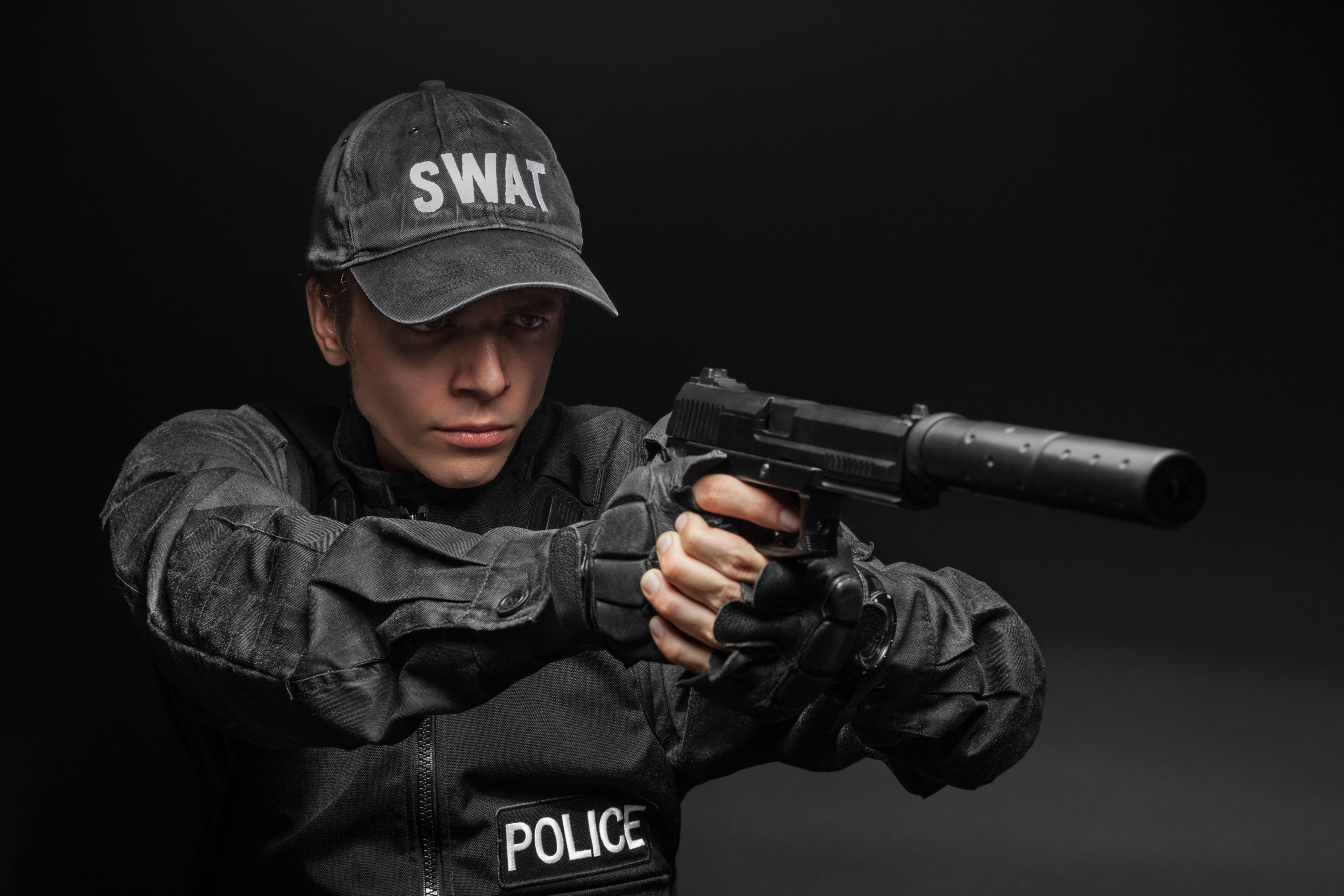 Man in SWAT uniform holding a pistol with suppressor HD Wallpaper