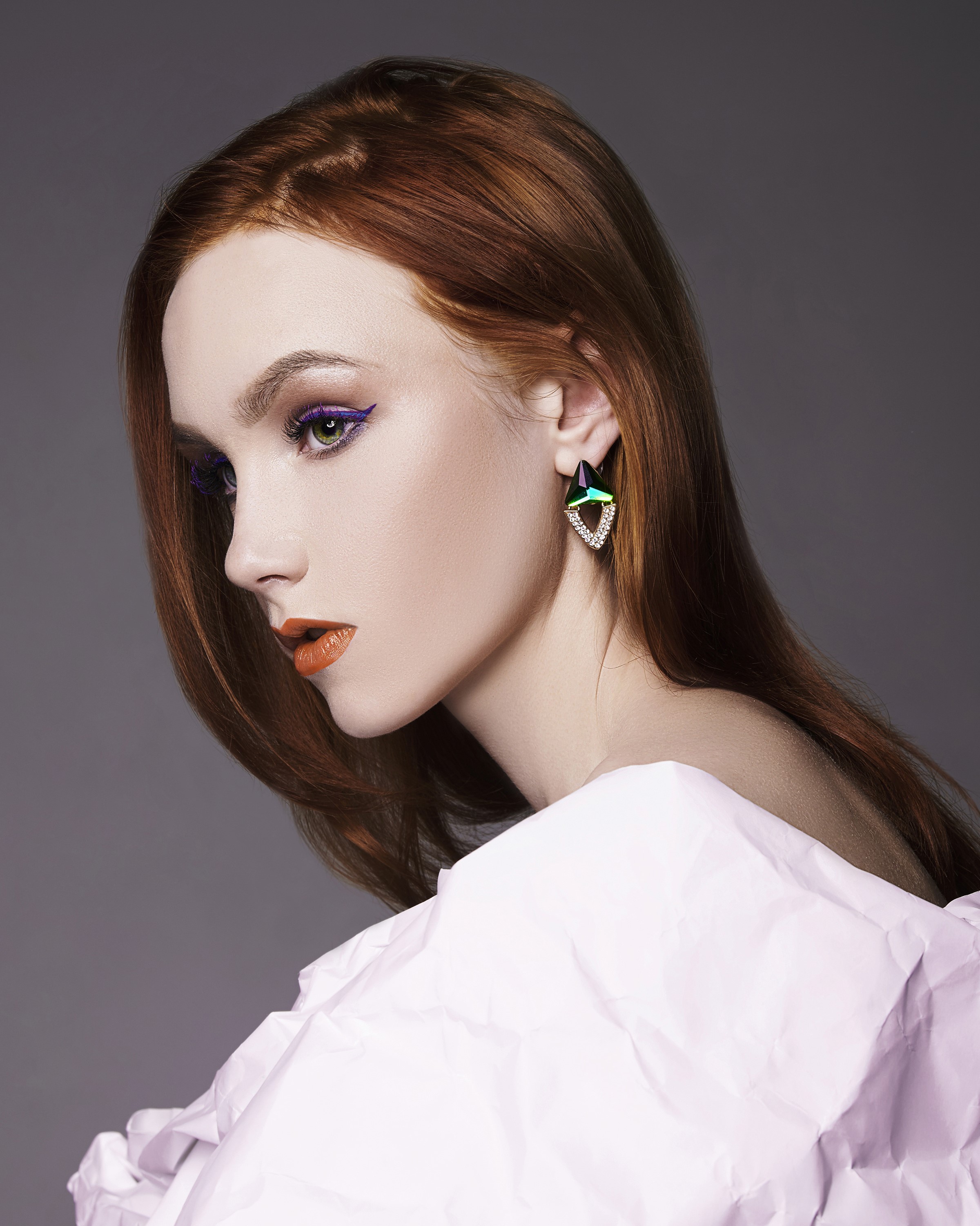 Woman with red hair and dramatic makeup wearing earrings HD Phone Wallpaper