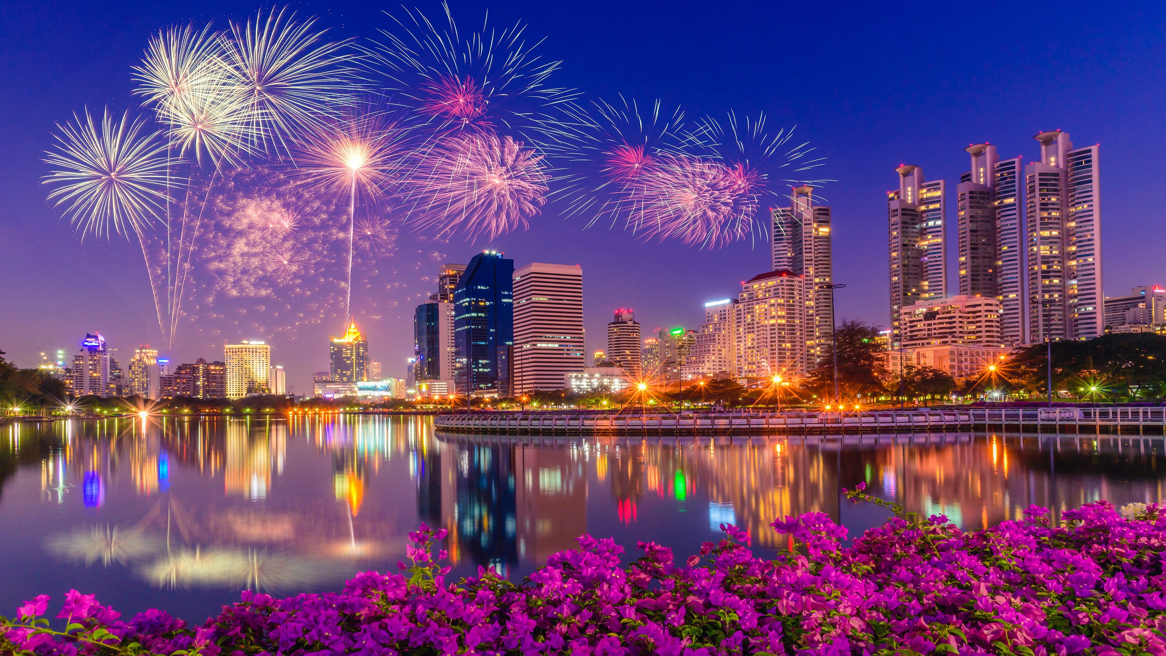 Fireworks over a city skyline at night HD Wallpaper