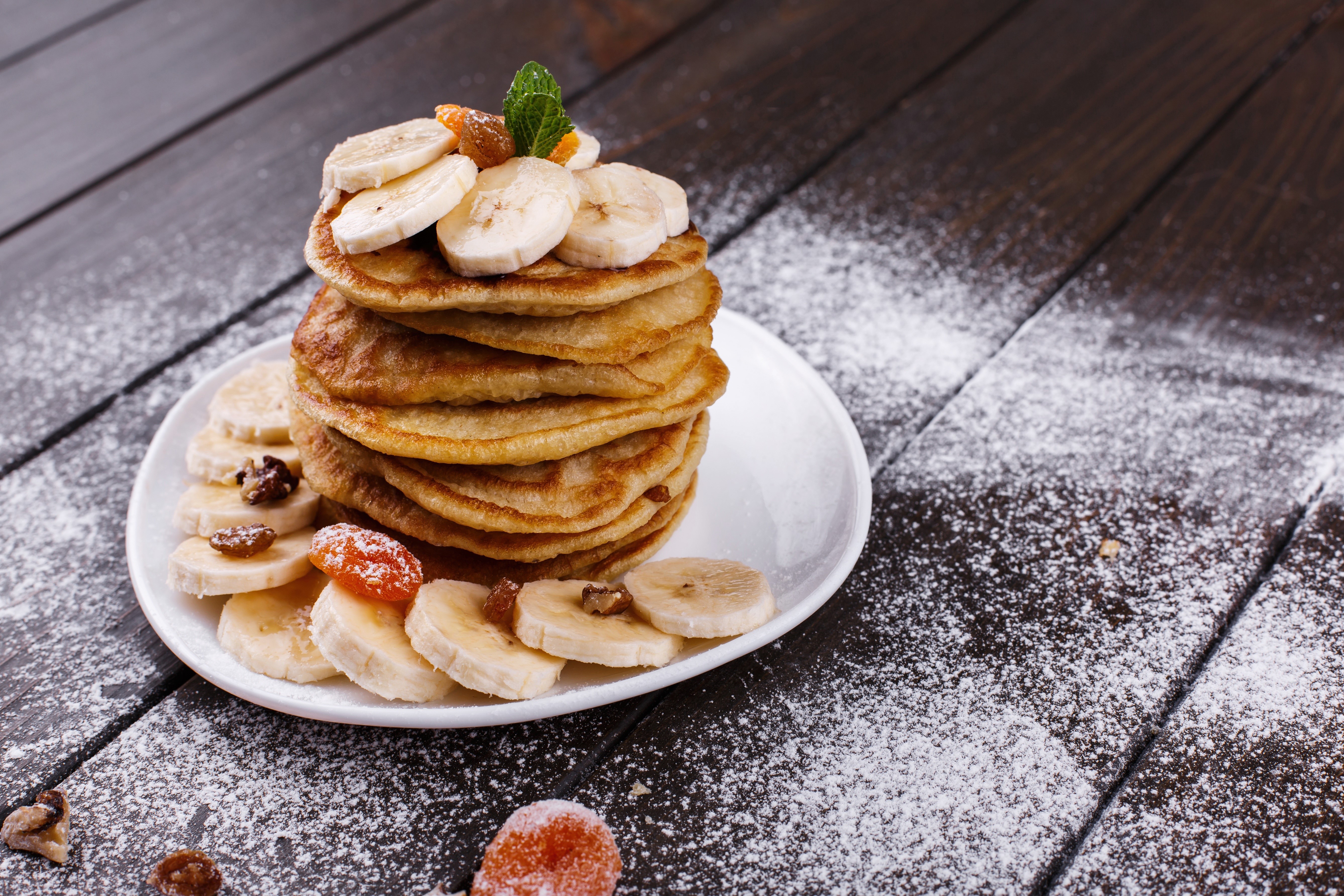 Pancakes with bananas and dried apricots on a plate HD Wallpaper