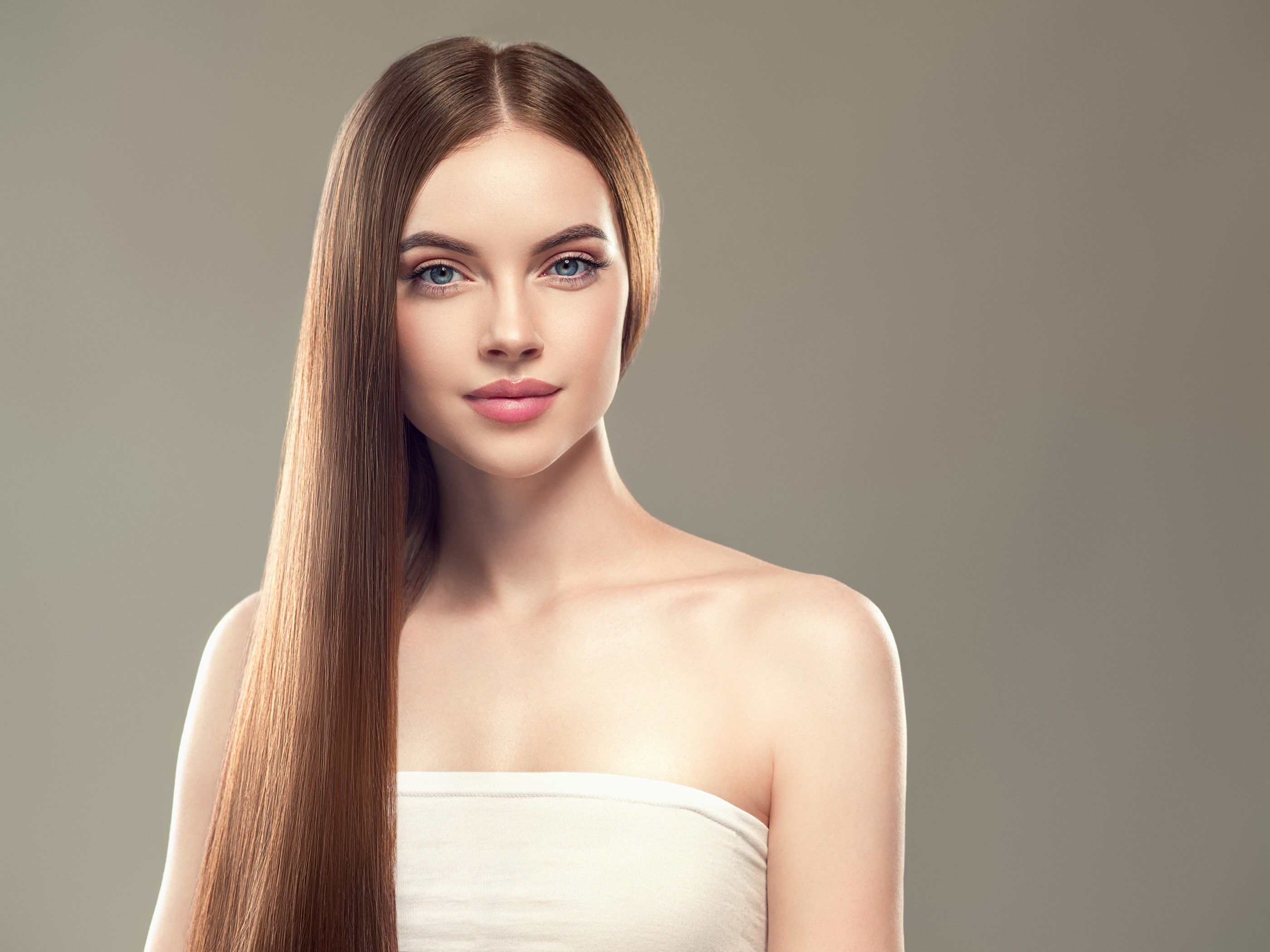 Woman with long brown hair against gray background HD Wallpaper
