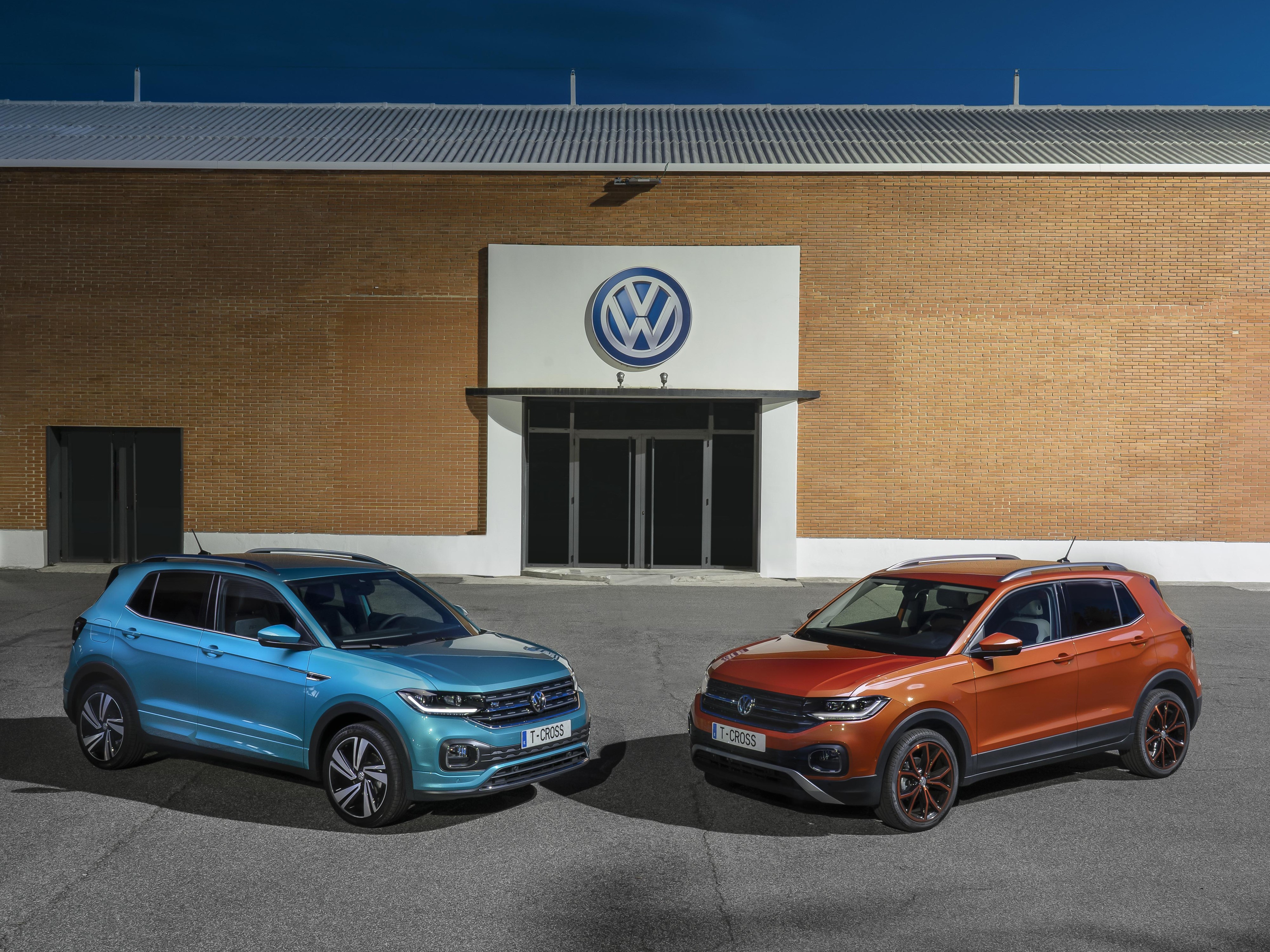 Two Volkswagen T-Cross cars in front of building HD Wallpaper