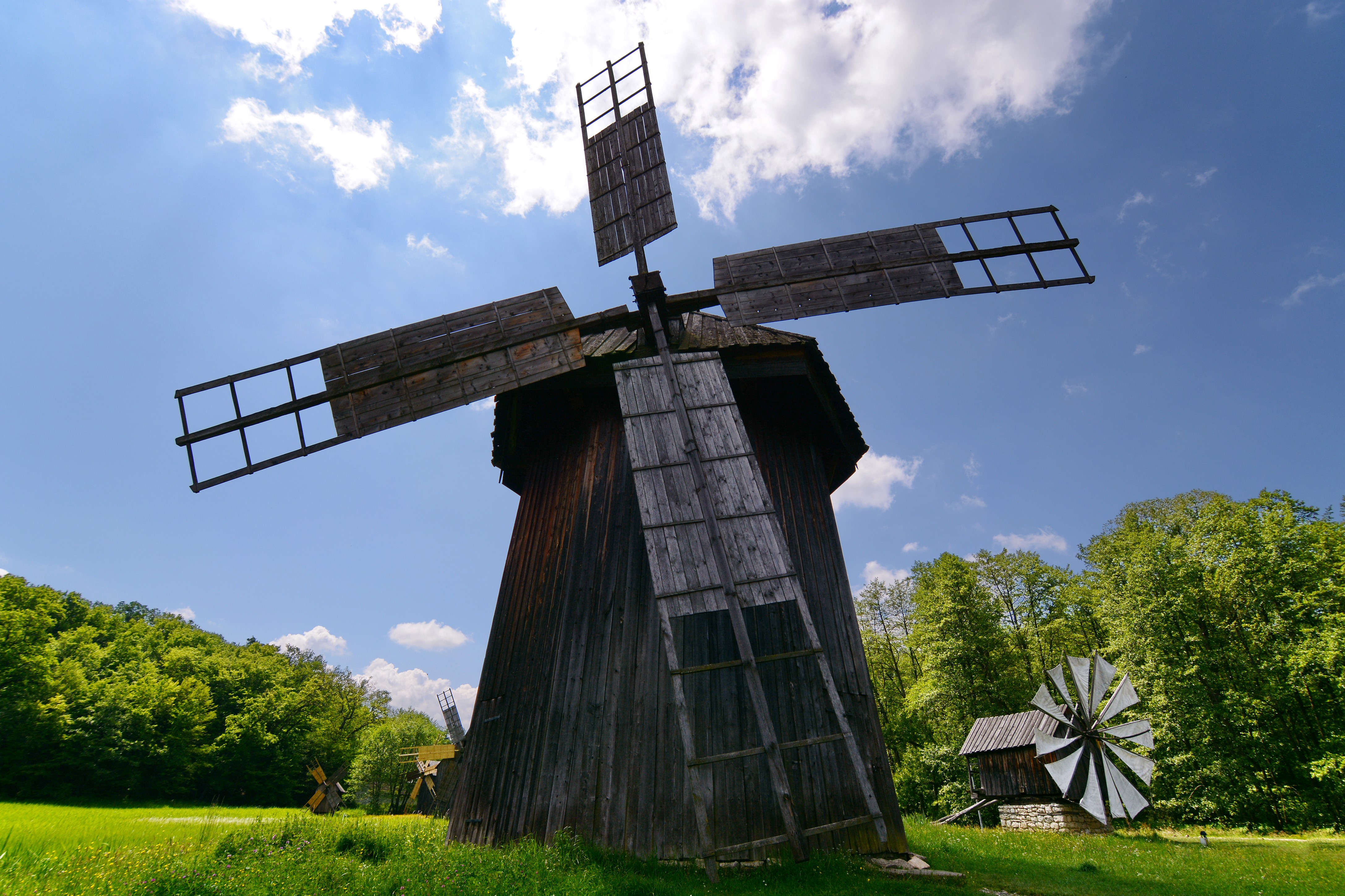 Wooden windmills in a field HD Wallpaper