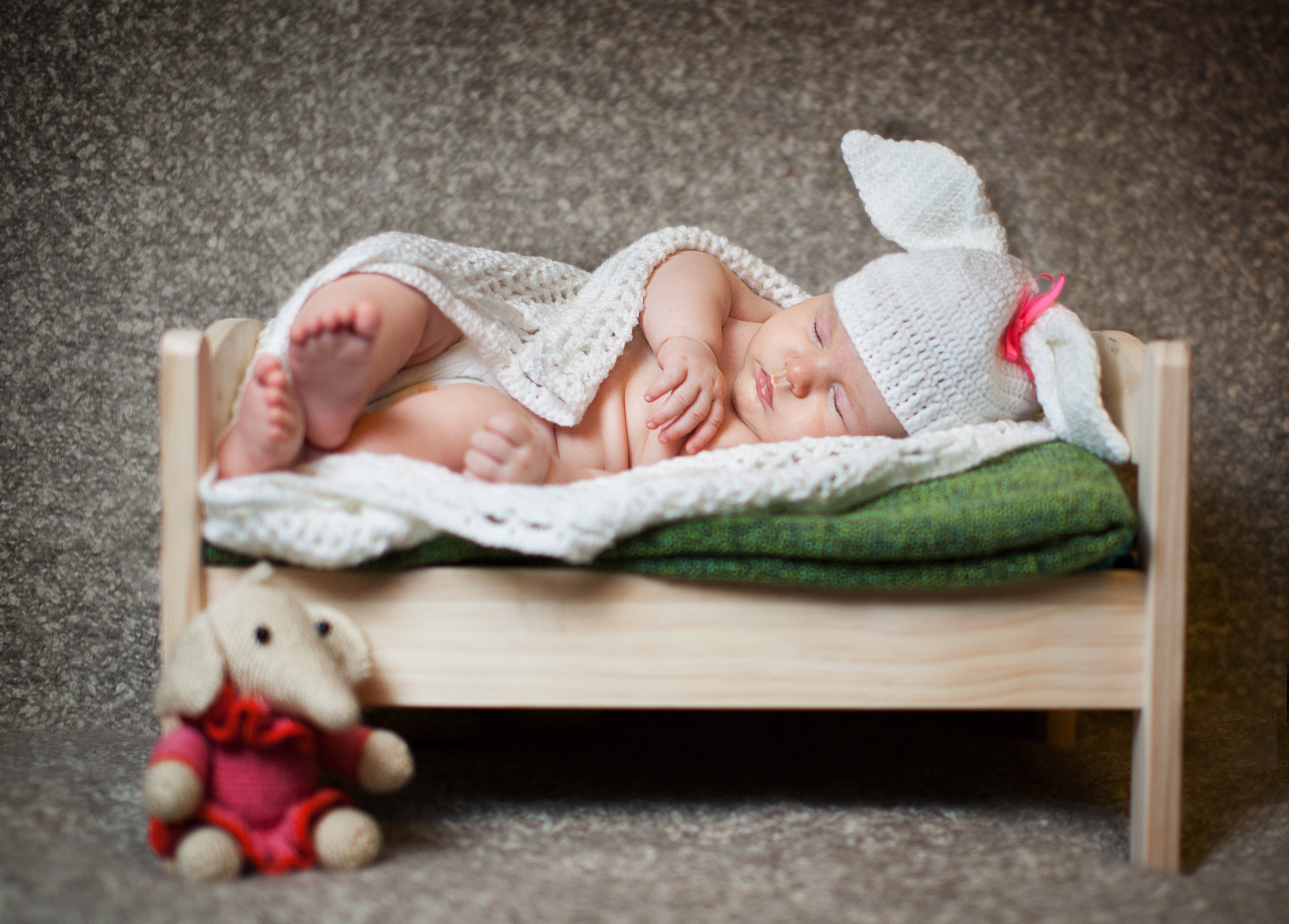 Baby sleeping in a crib with a bunny hat HD Wallpaper