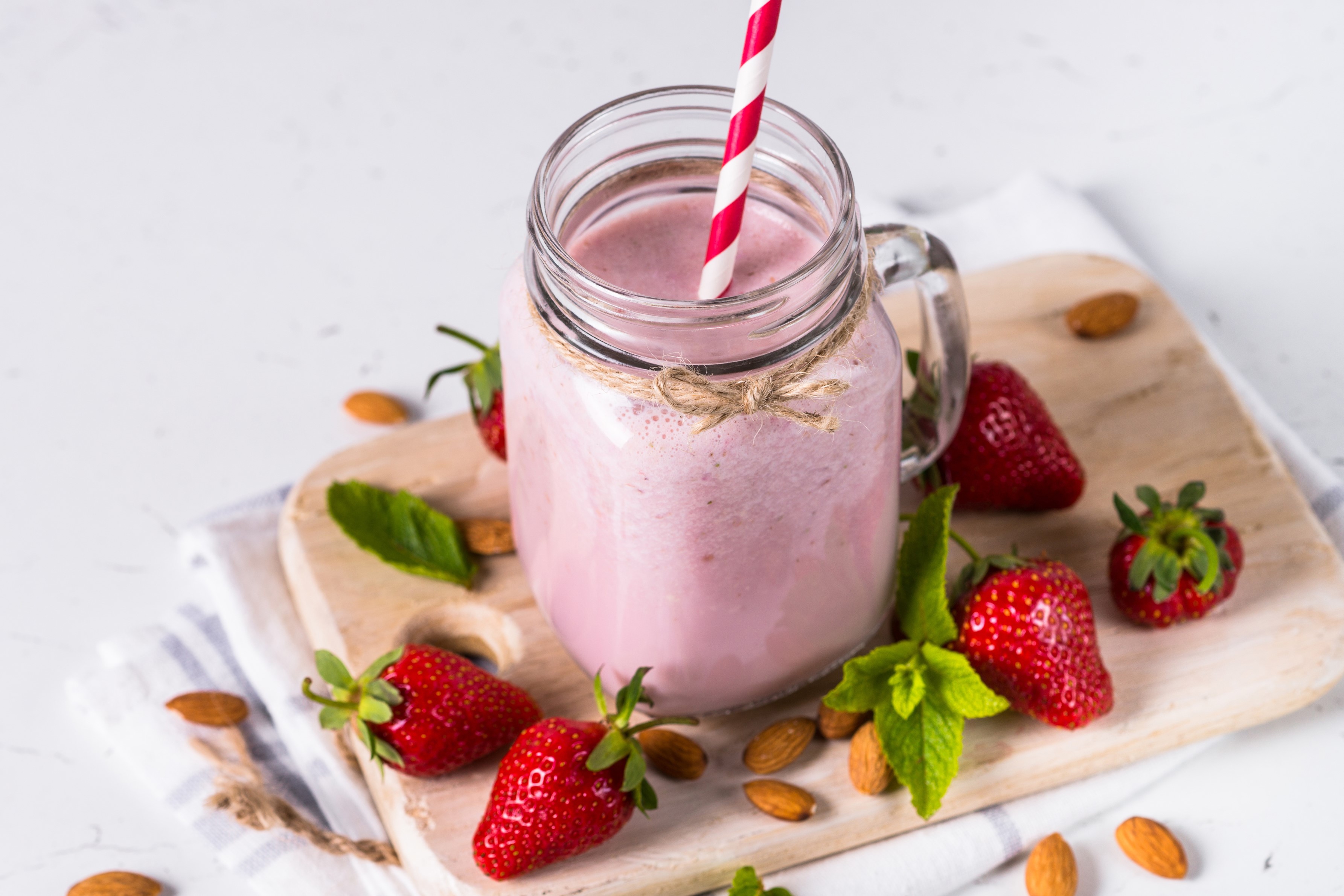 Strawberry almond smoothie in a mason jar with fresh strawberries HD Wallpaper