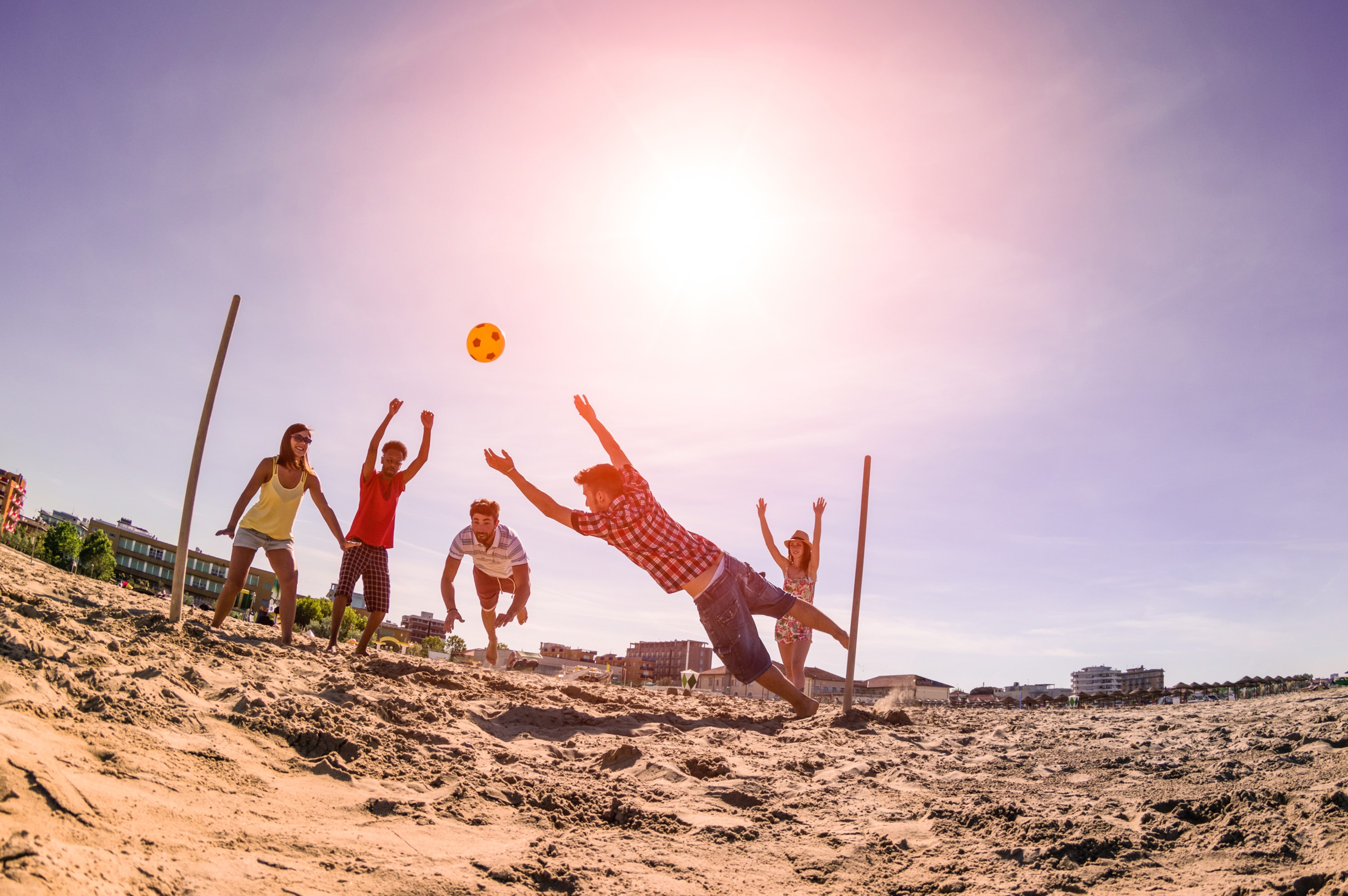 People playing volleyball on a sandy beach HD Wallpaper