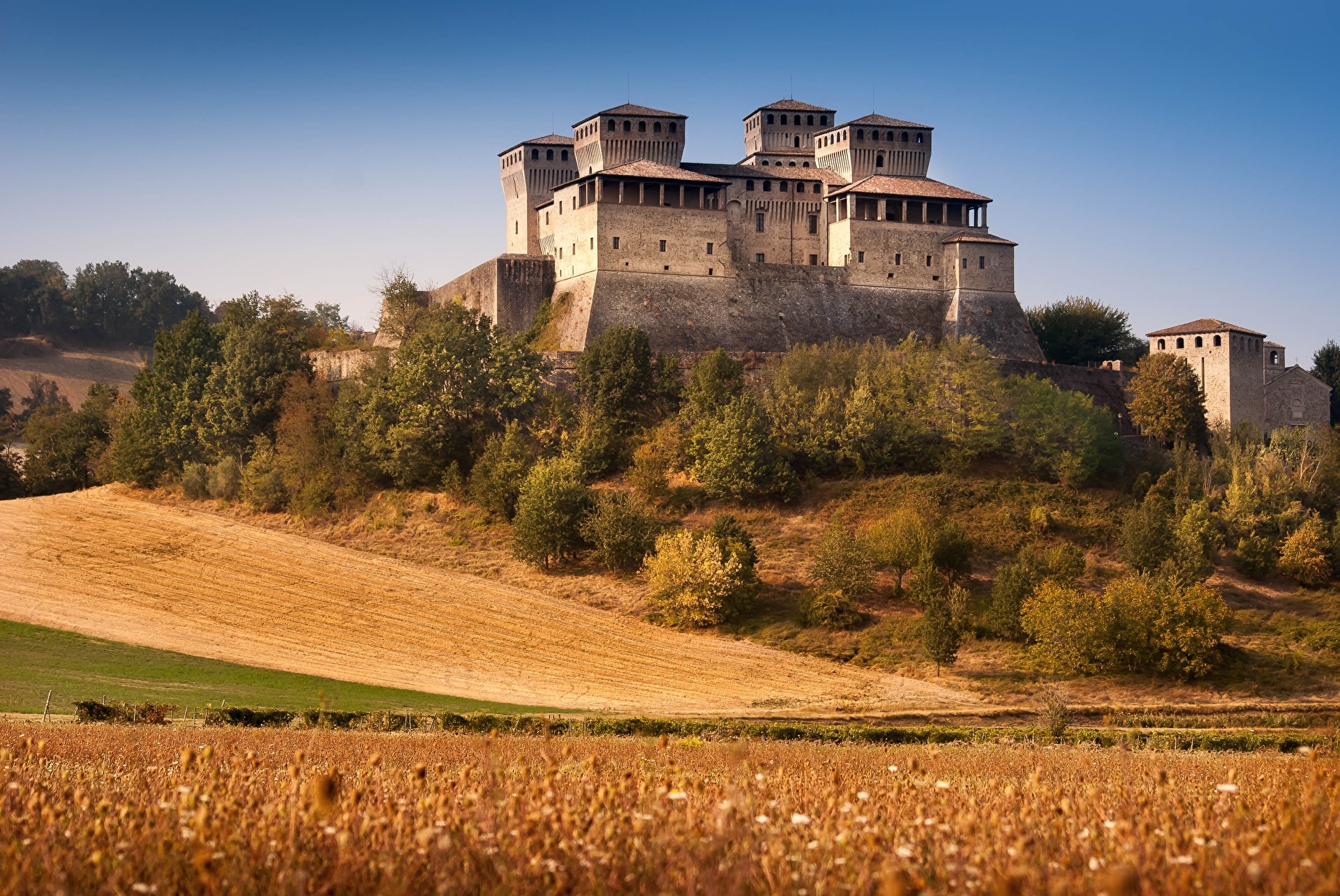Castle of Torrechiara in Parma, Italy with fields HD Wallpaper