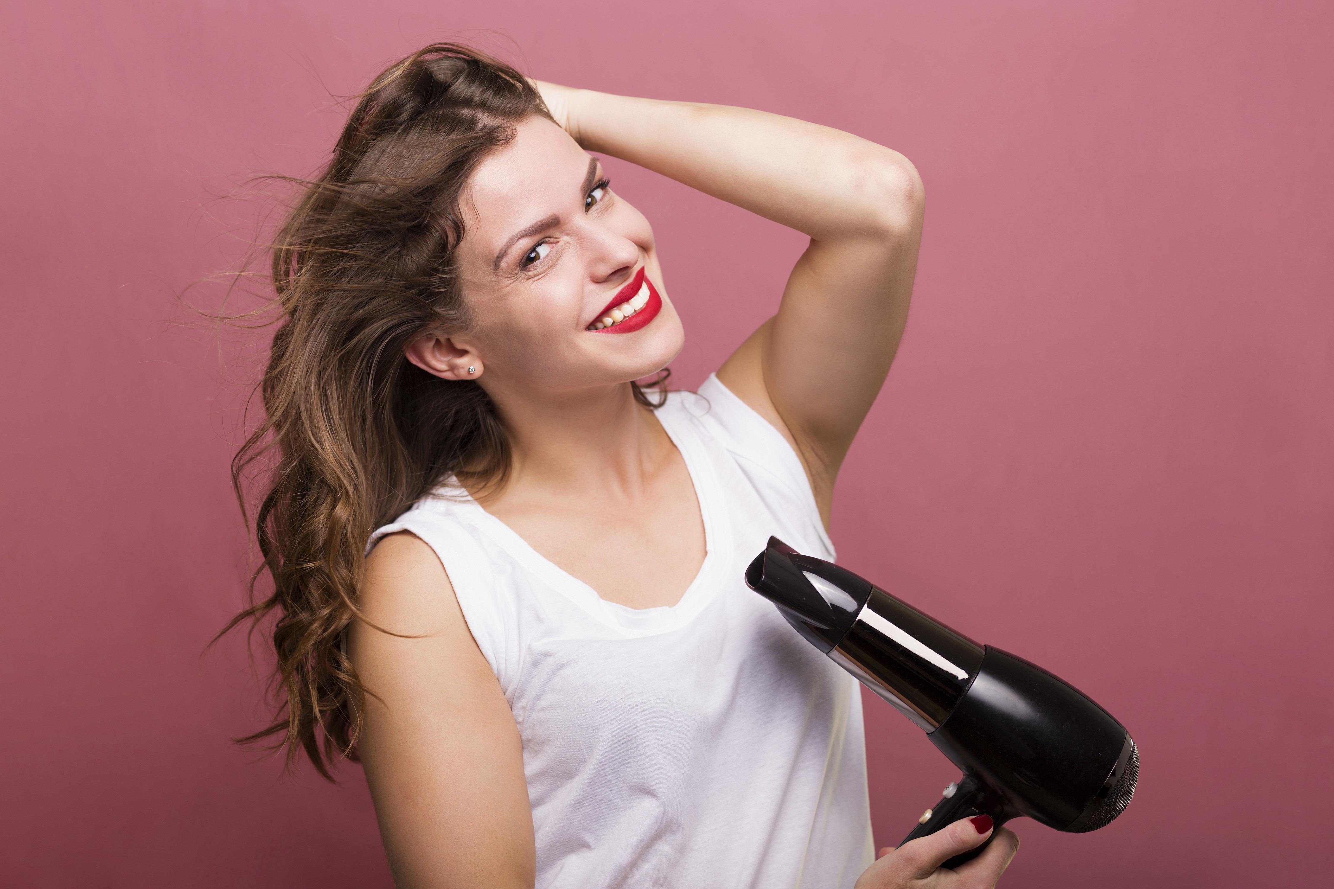 Woman with brown hair using a hair dryer HD Wallpaper