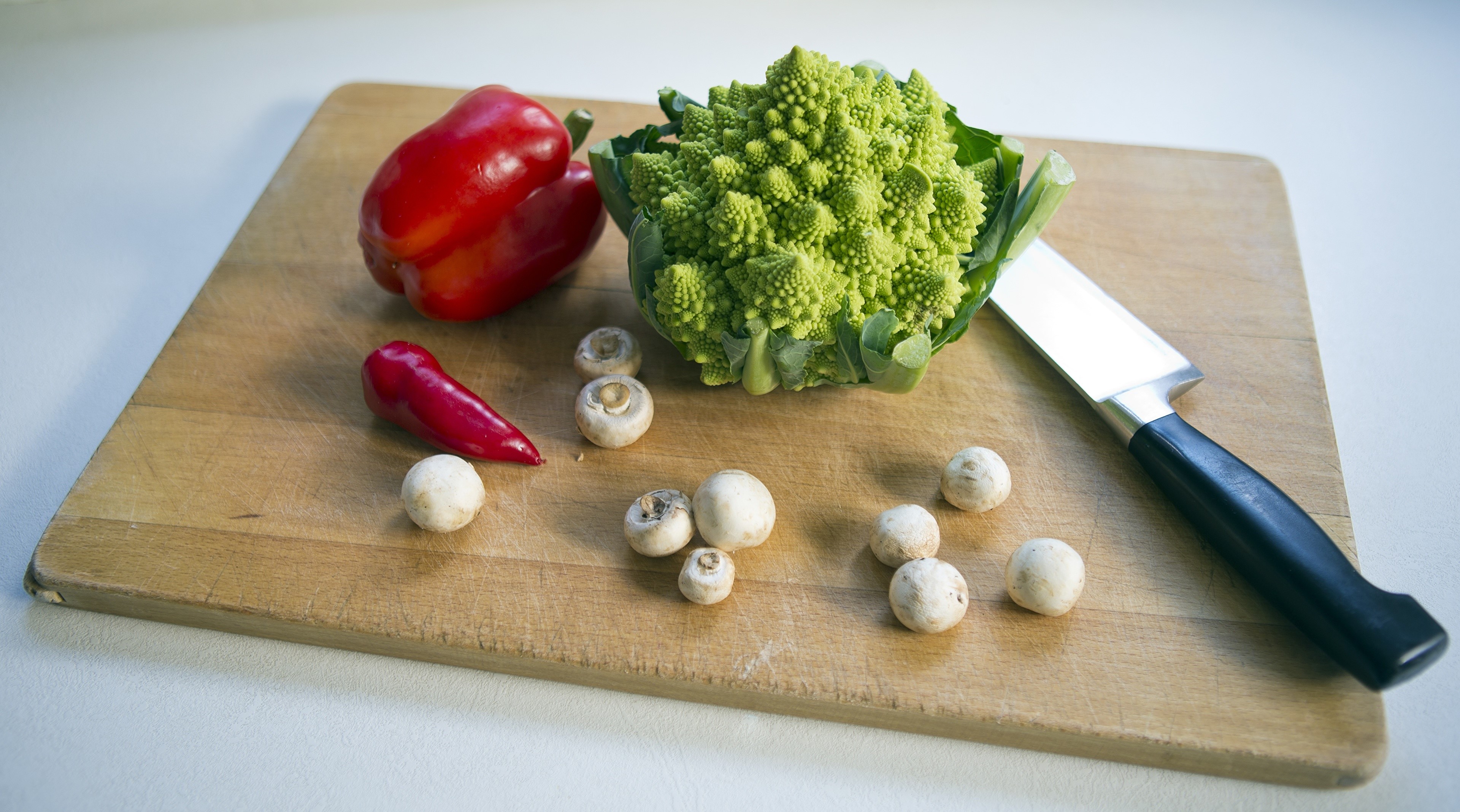 Bell pepper, Romanesco broccoli, mushrooms, and knife on cutting board HD Wallpaper