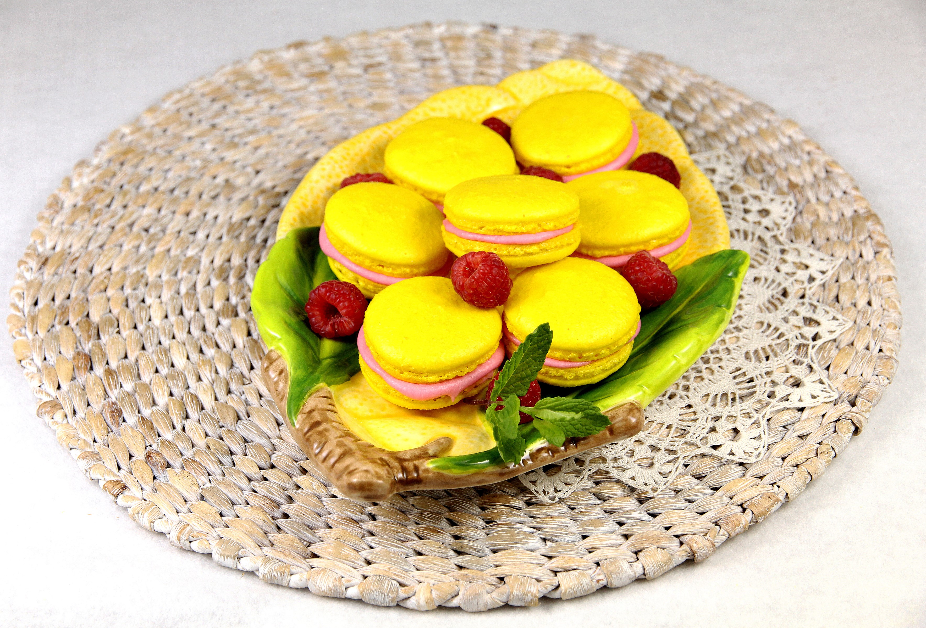 Yellow macarons with raspberries on a decorative plate HD Wallpaper
