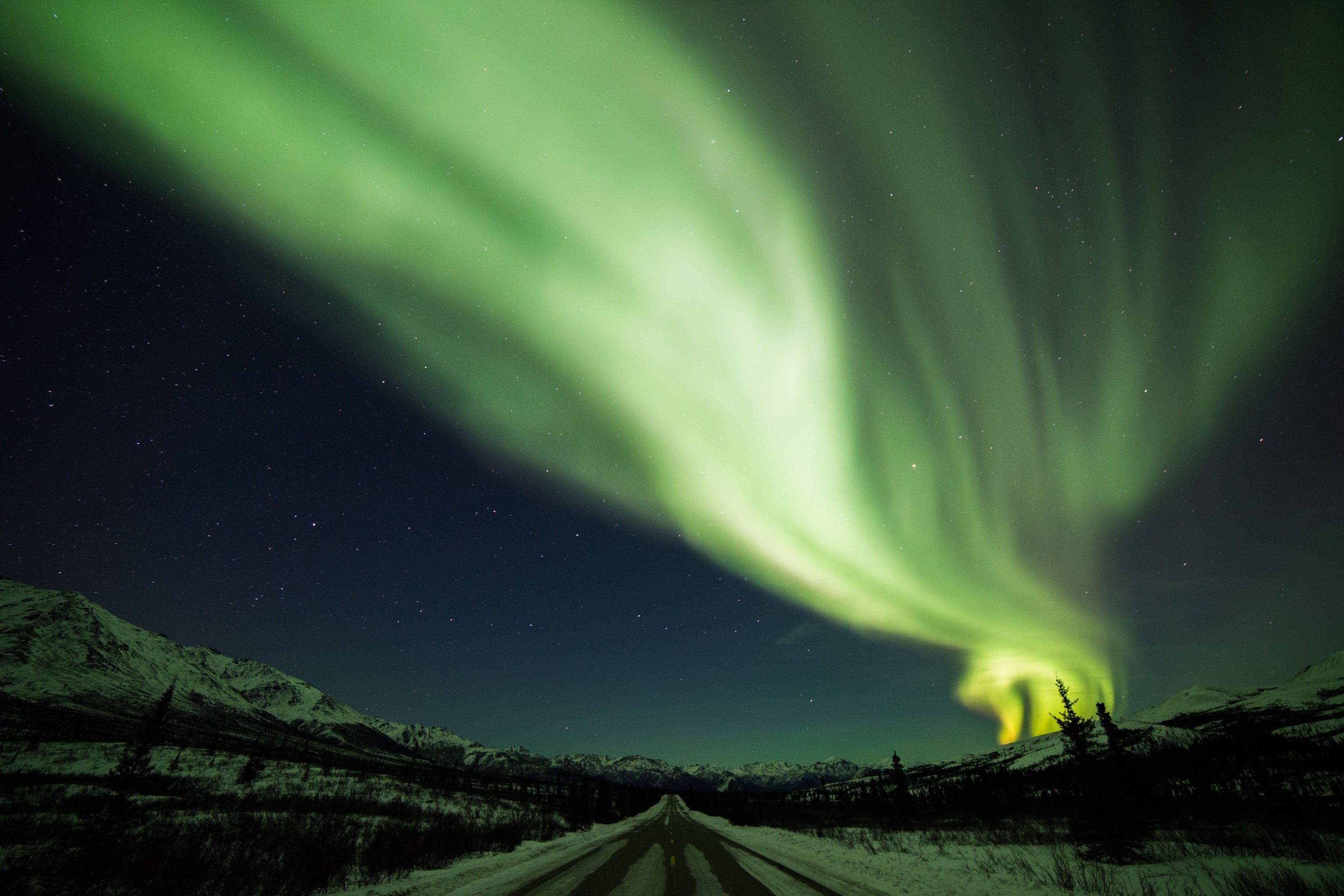 Aurora Borealis over a snowy road at night HD Wallpaper