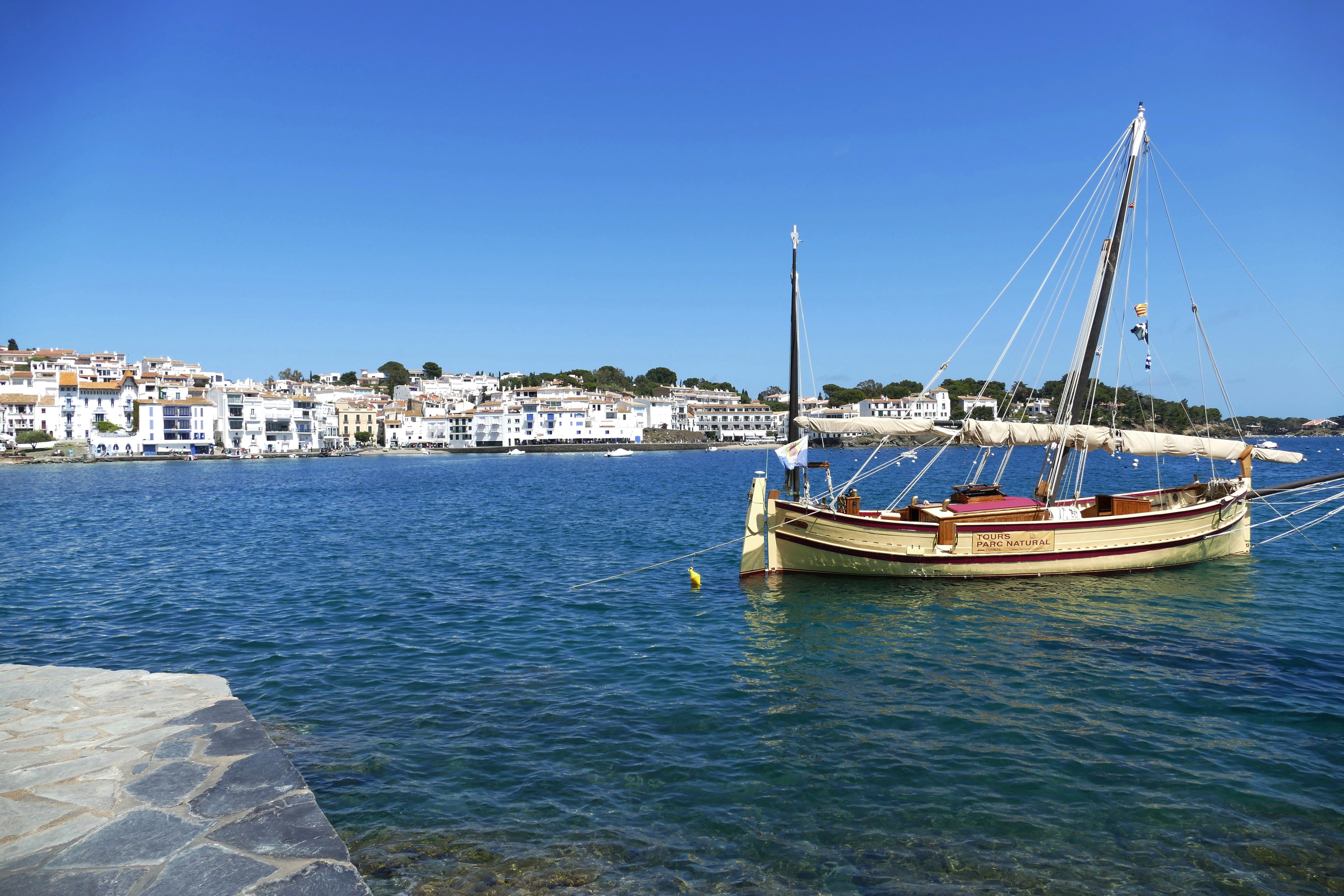 Sailboat in a bay with white houses in Spain HD Wallpaper