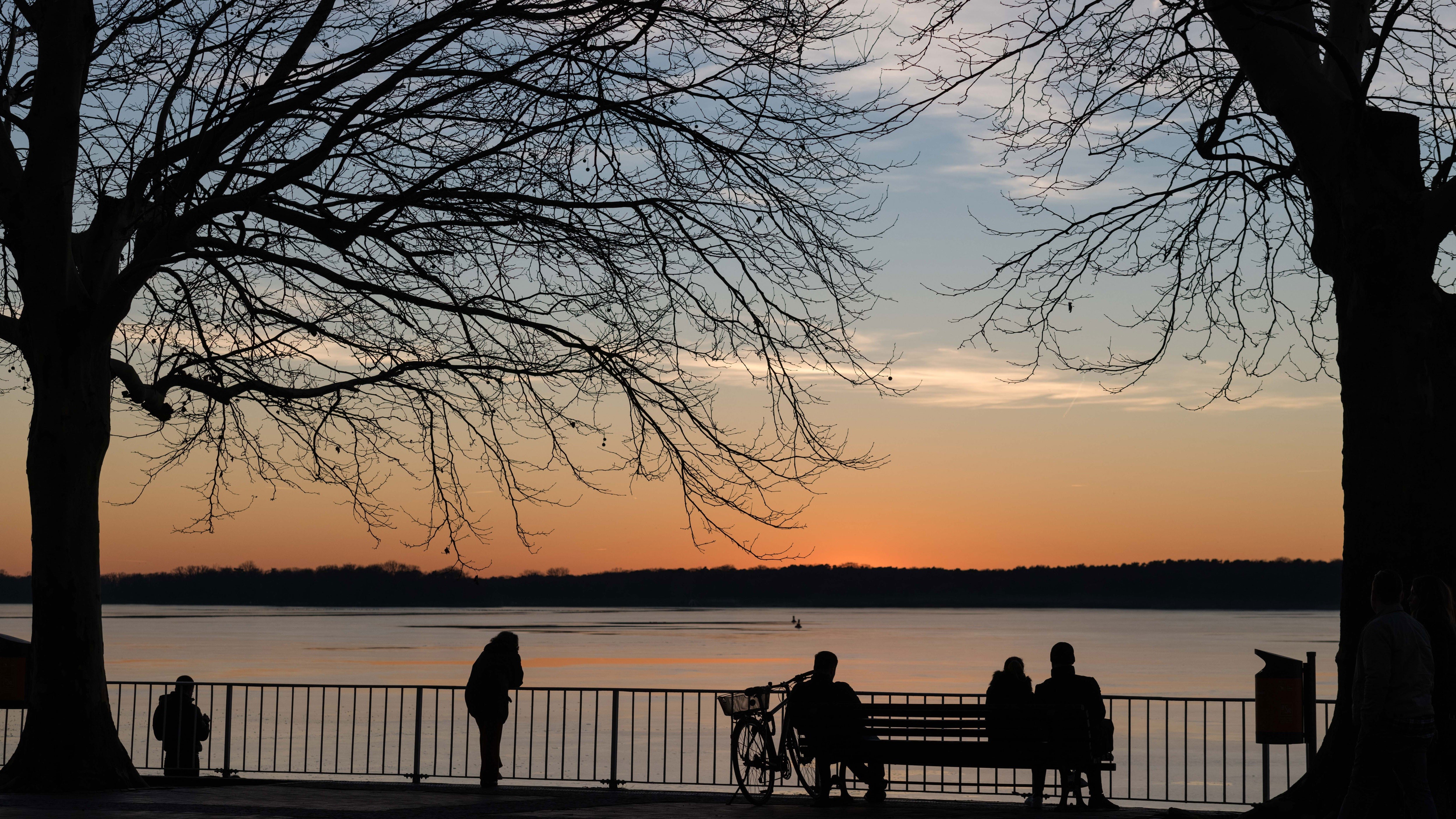 Silhouettes by the waterfront at sunset in Berlin HD Wallpaper