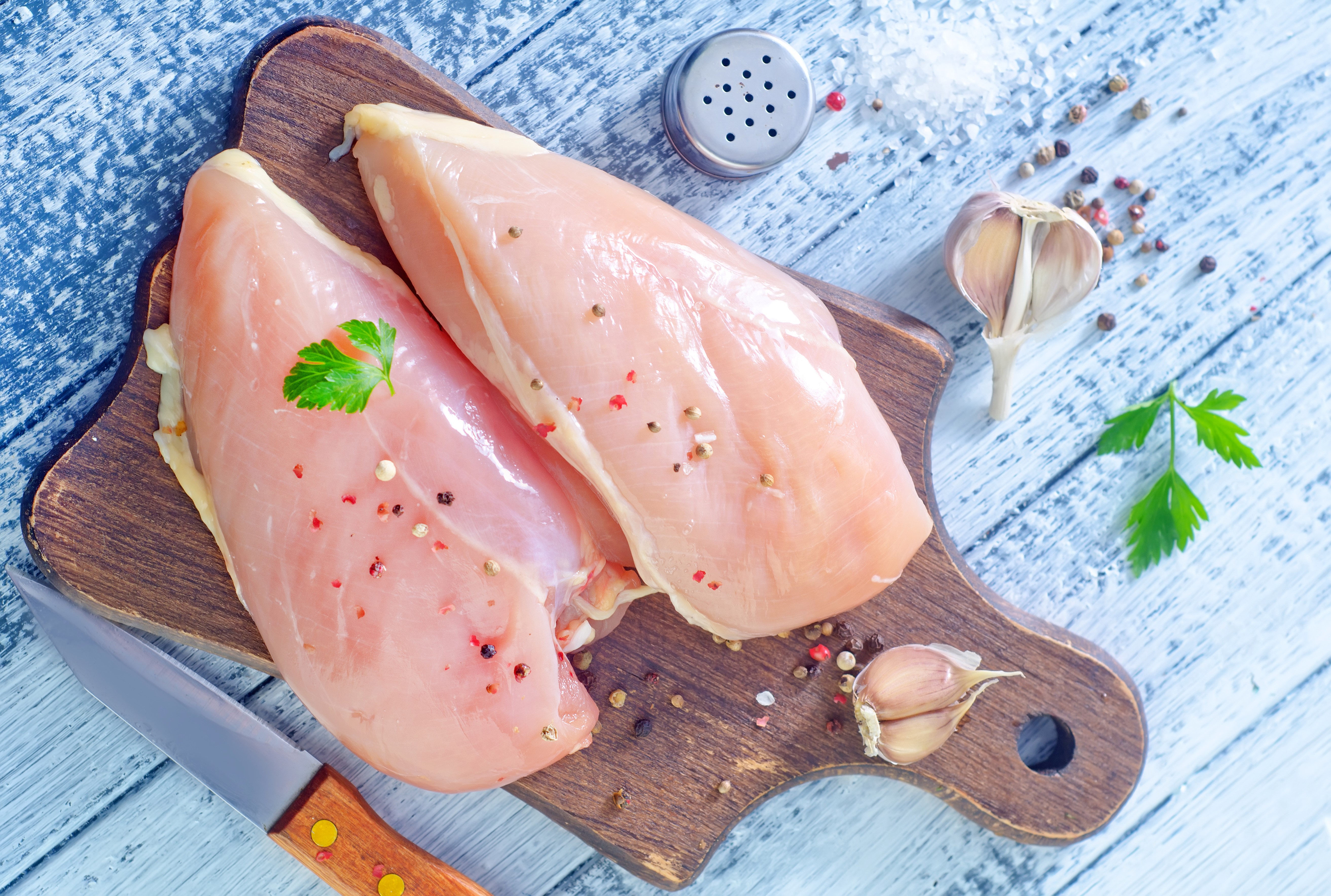 Raw chicken breasts with spices and garlic on a cutting board HD Wallpaper
