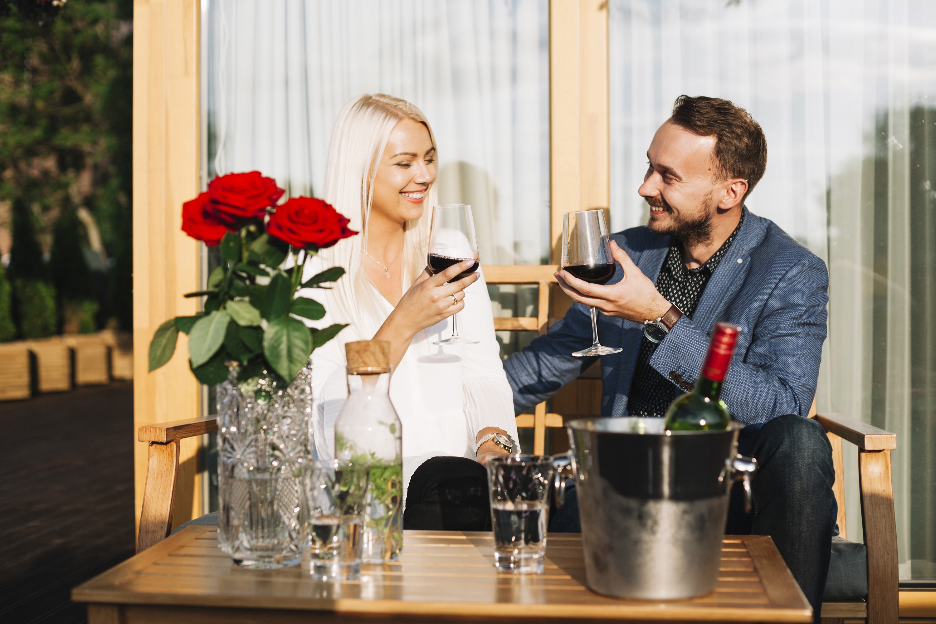 Couple enjoying wine with roses on a table HD Wallpaper