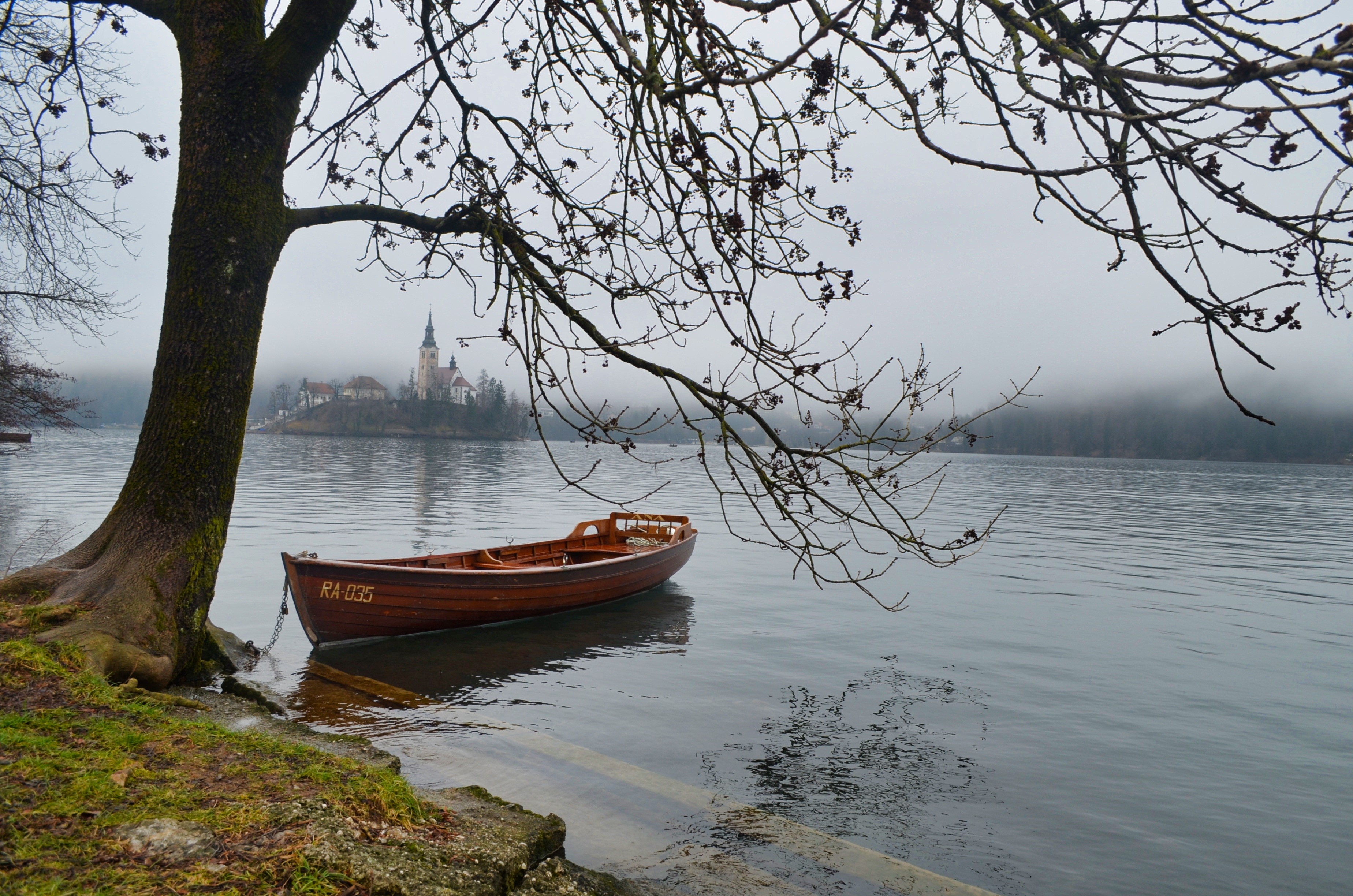 Wooden boat on Bled Lake, Slovenia with church on island HD Wallpaper