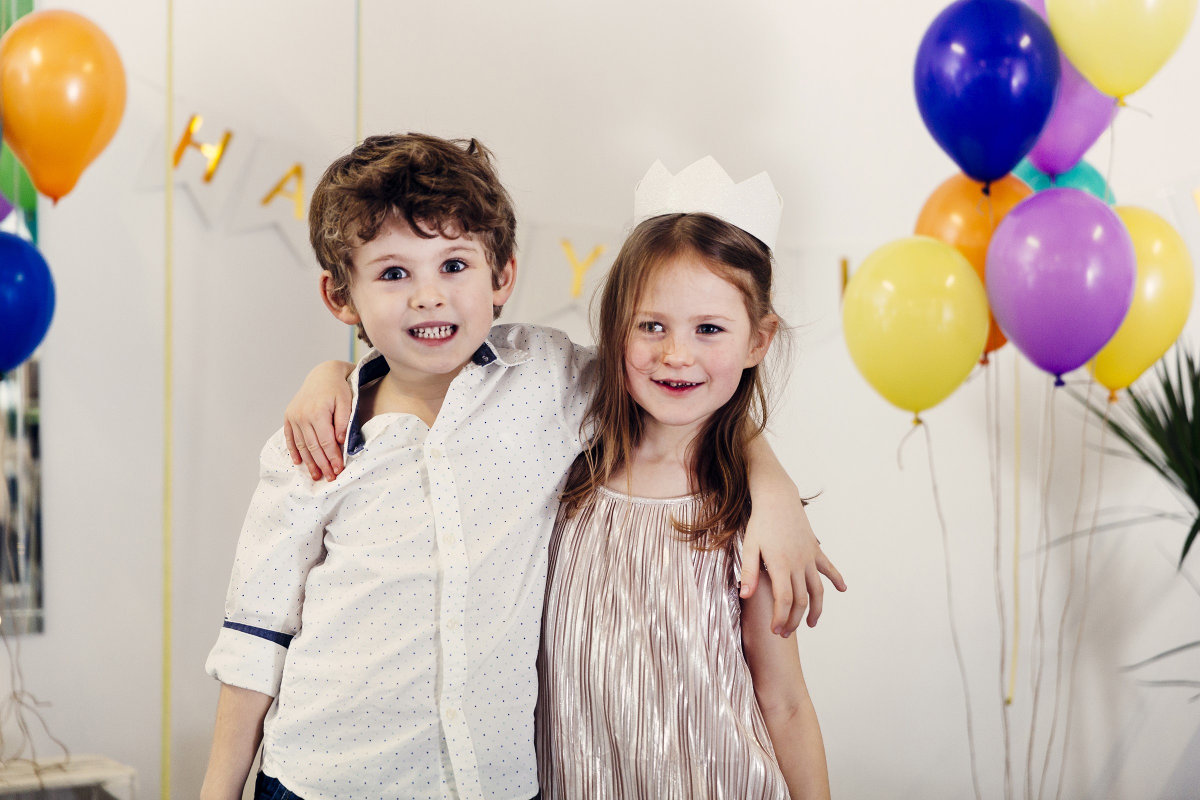 Children hugging at a birthday party with balloons HD Wallpaper