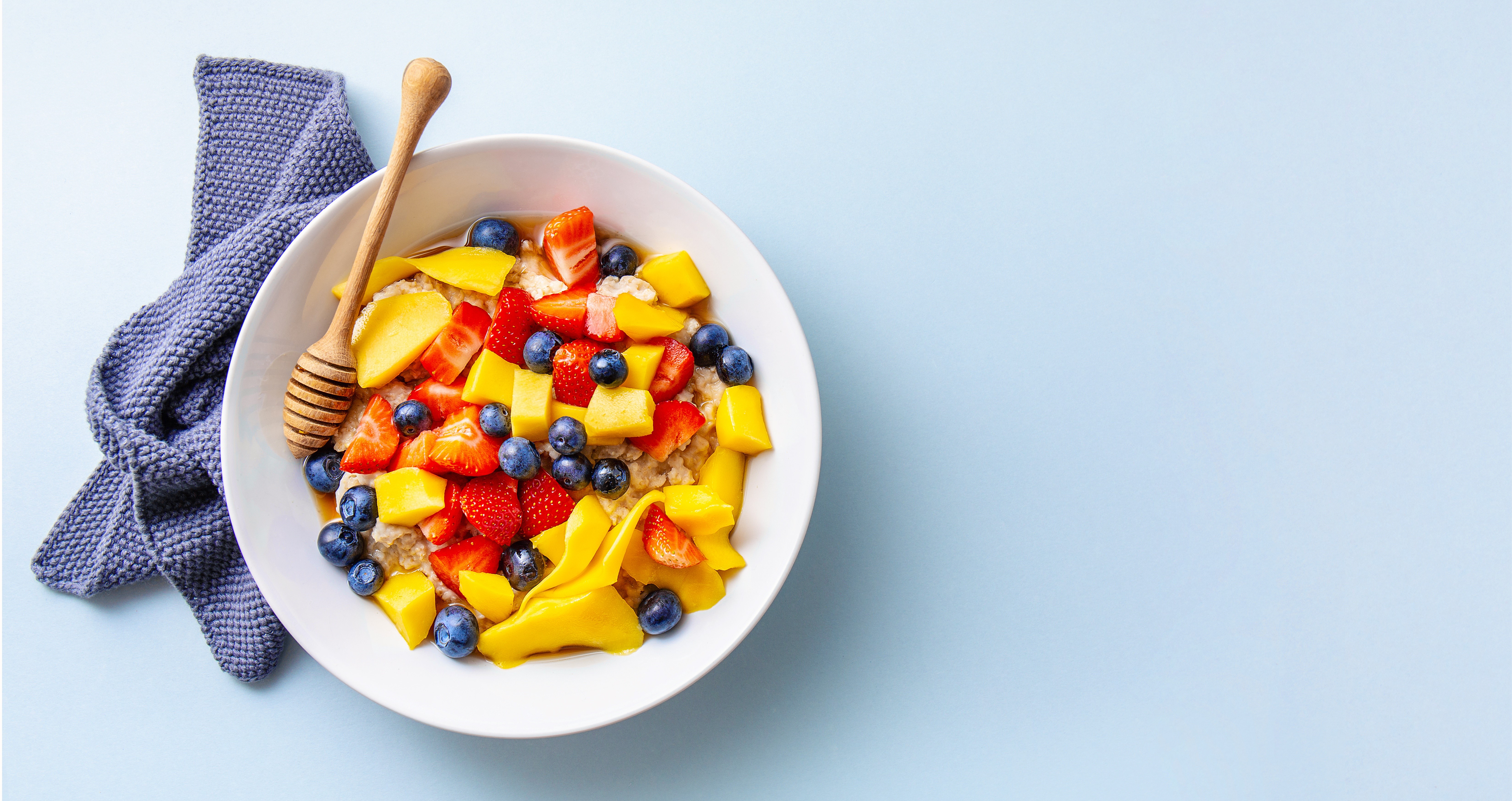 Bowl of muesli with strawberries, blueberries, mango, and honey HD Wallpaper