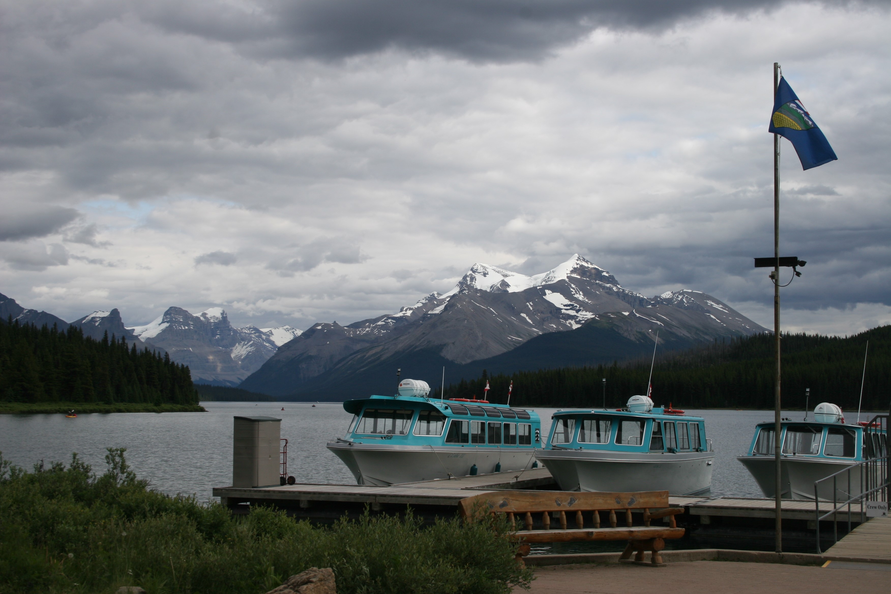 Boats docked at Lake Maligne with mountains in Jasper Park, Alberta HD Wallpaper