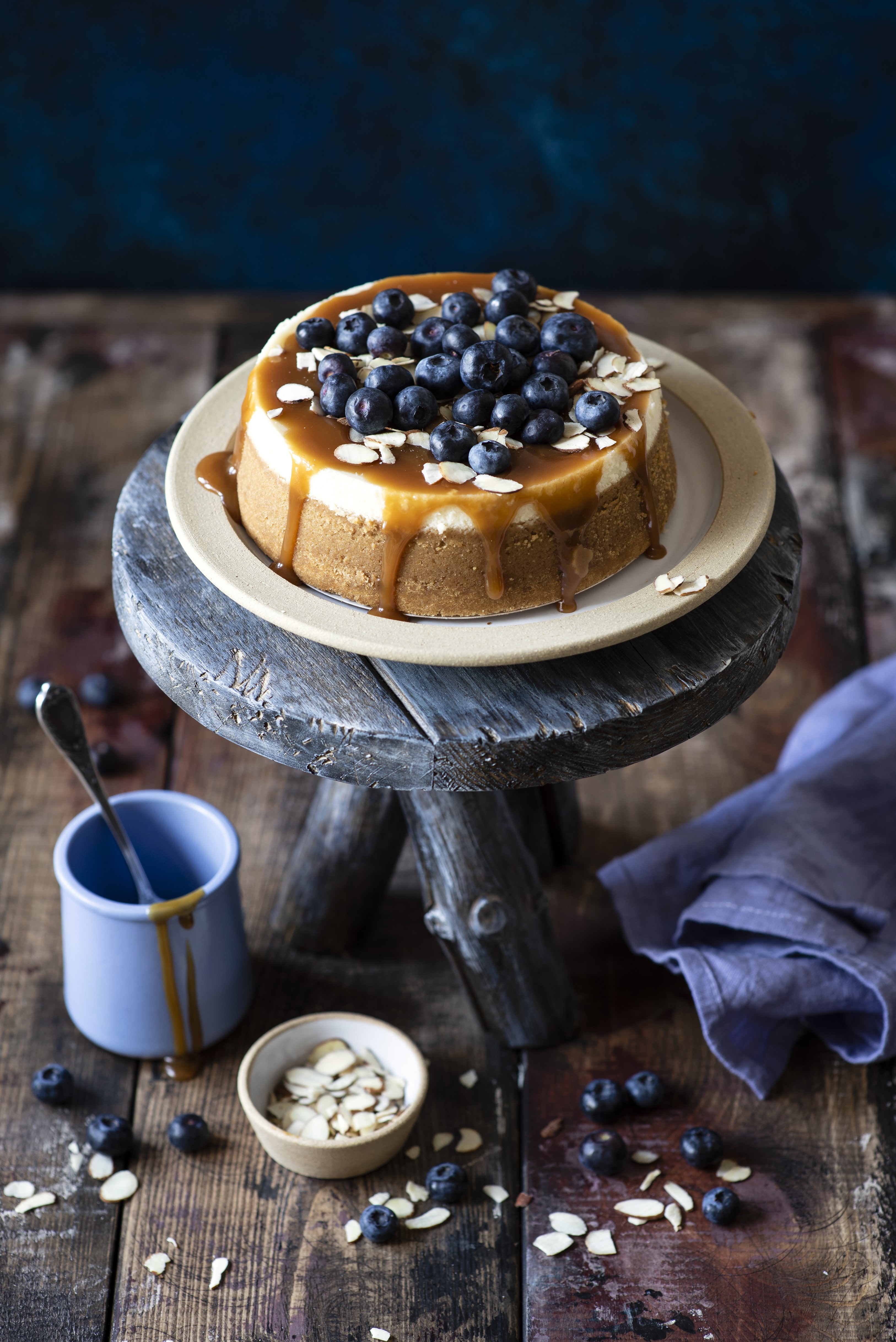 Cheesecake with blueberries and caramel on a wooden stand HD Phone Wallpaper