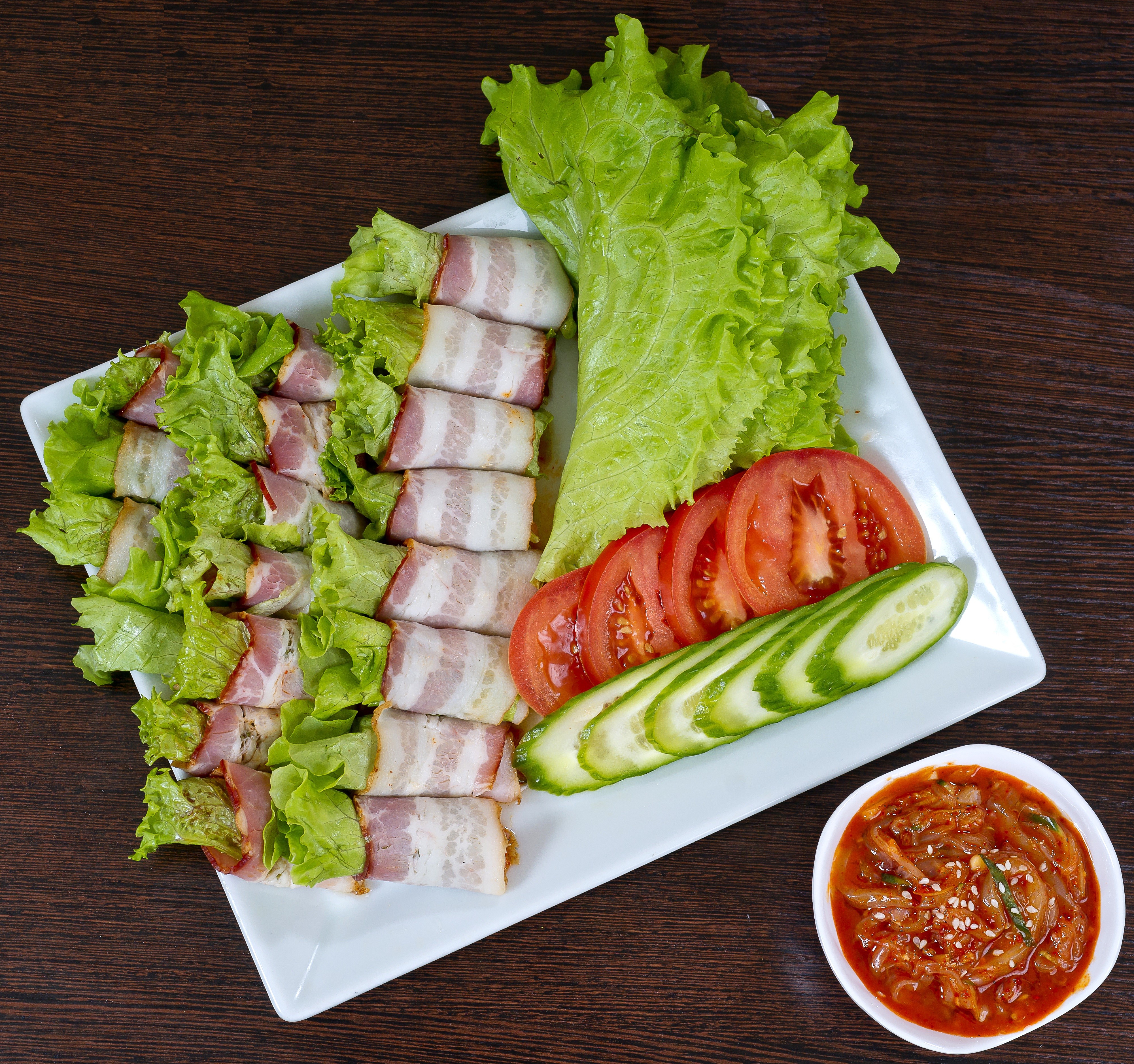 Bacon-wrapped lettuce rolls with tomatoes, cucumbers, and kimchi HD Wallpaper