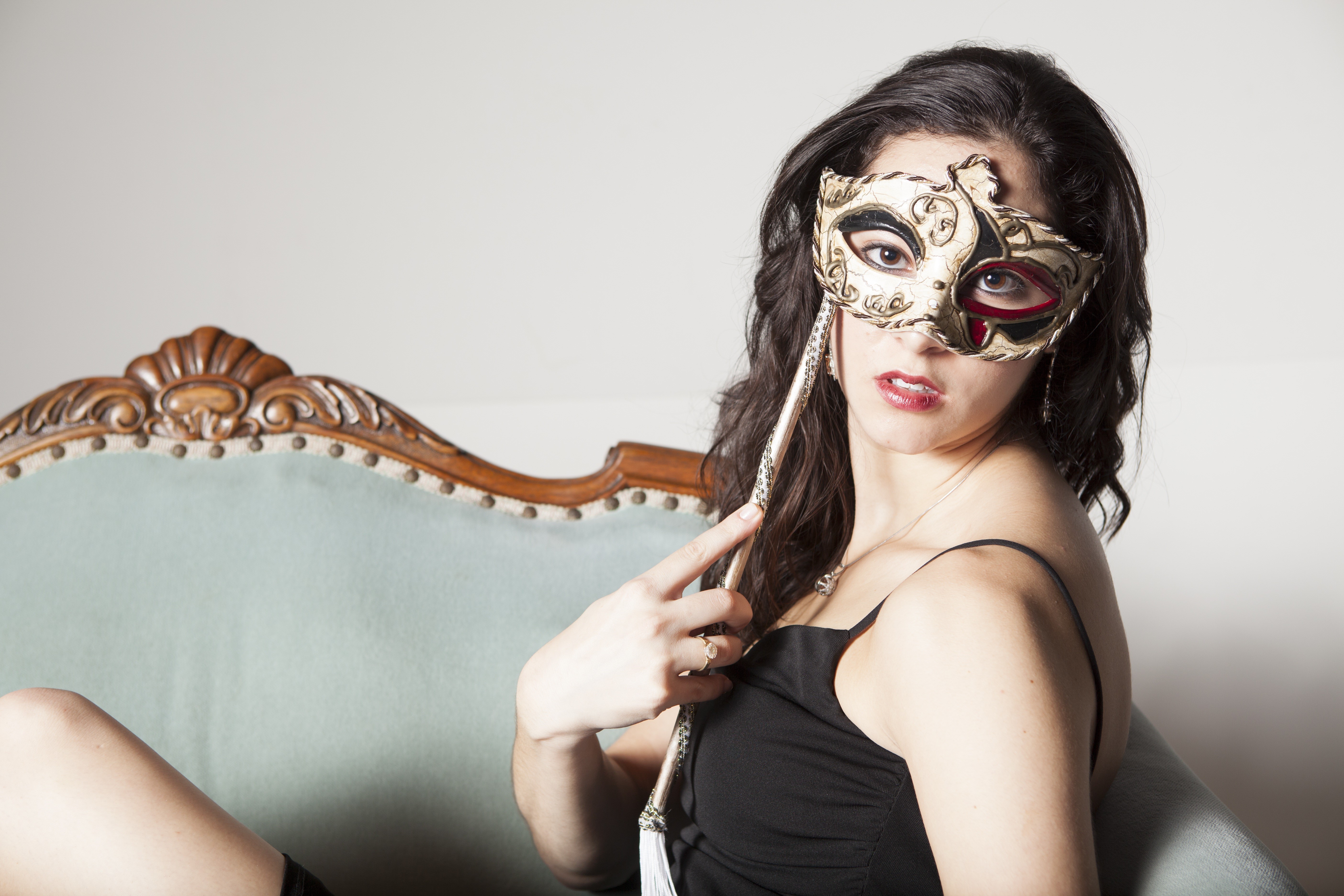 Brunette girl with mask on ornate couch HD Wallpaper