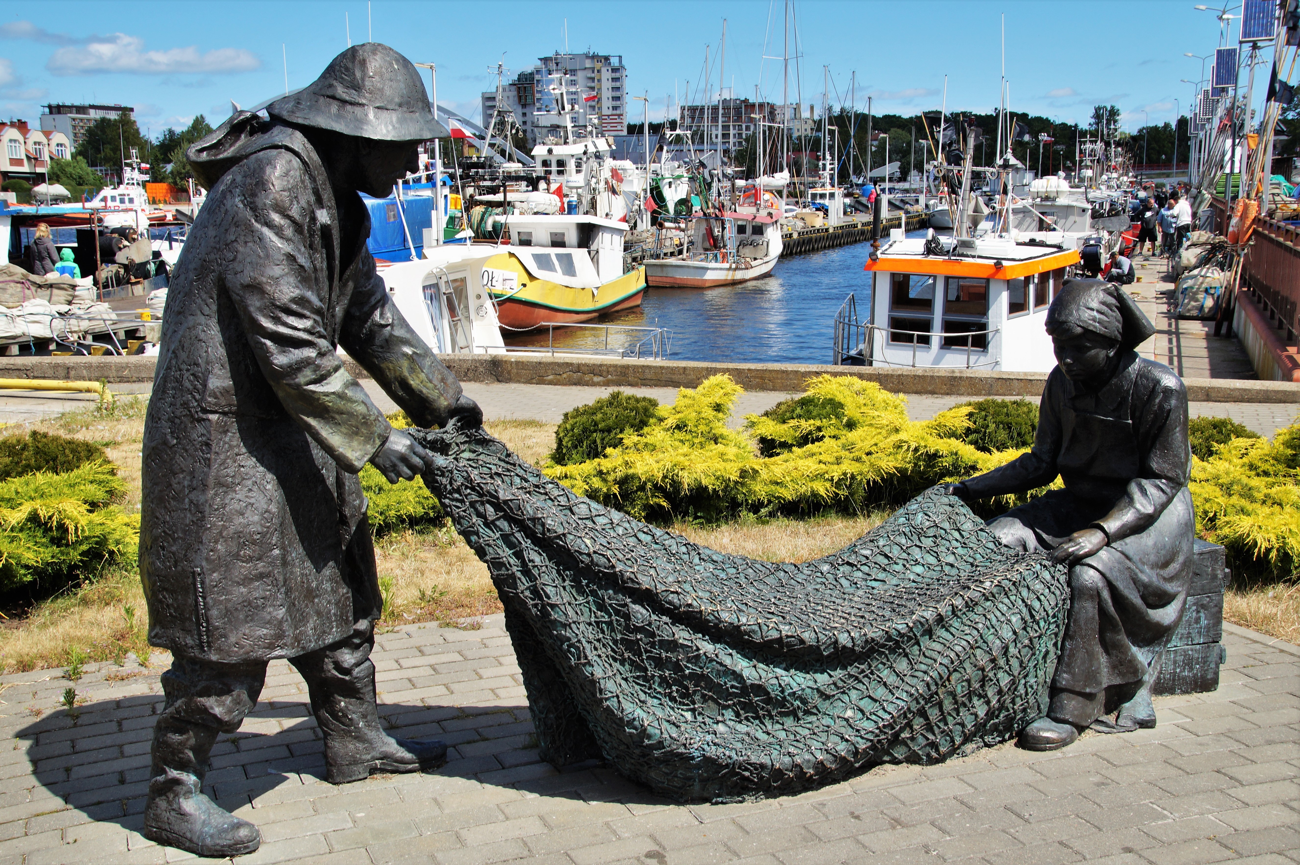 Fisherman and woman with net sculpture in Kolobrzeg, Poland HD Wallpaper