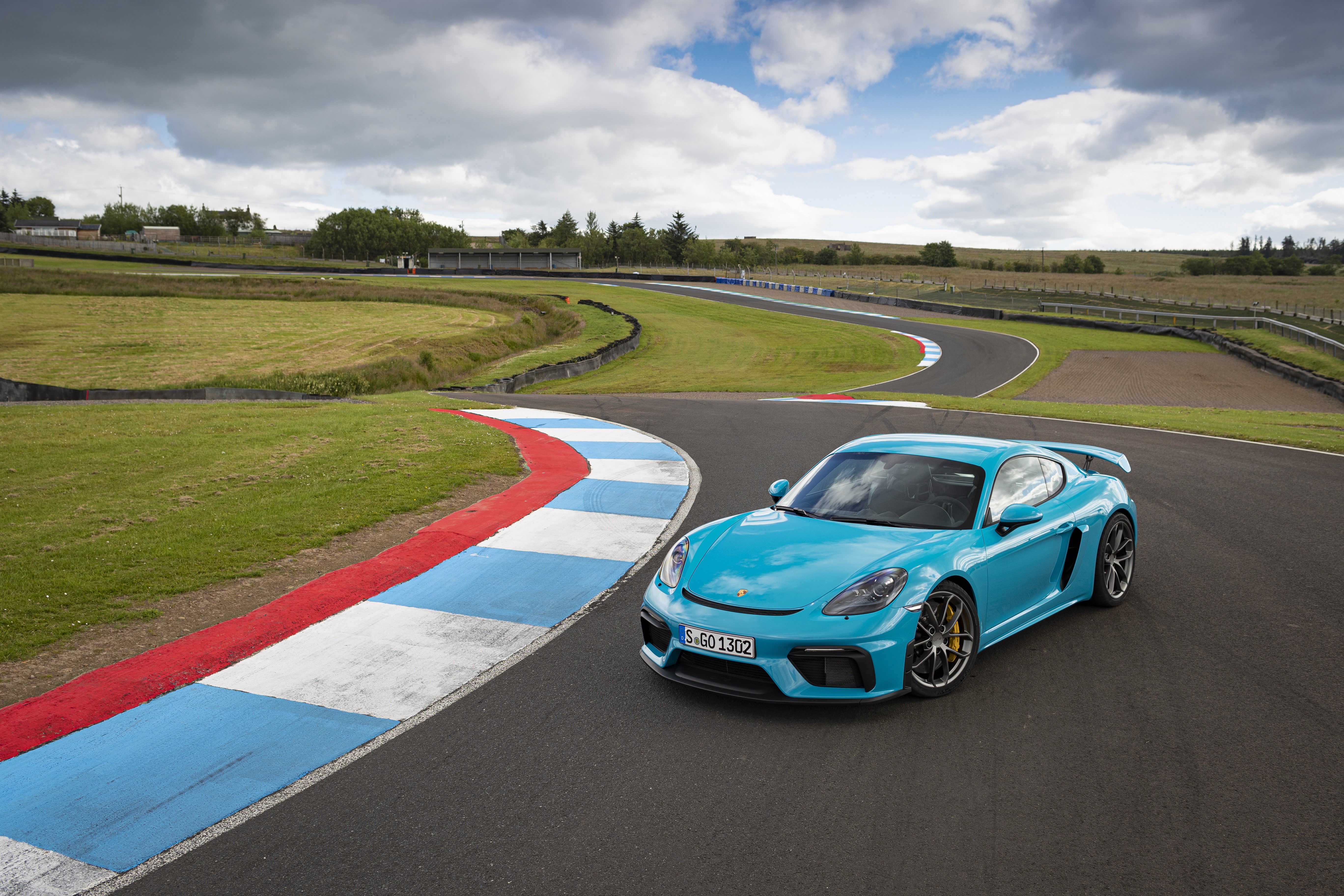 Porsche 718 Cayman GT4 on a race track HD Wallpaper