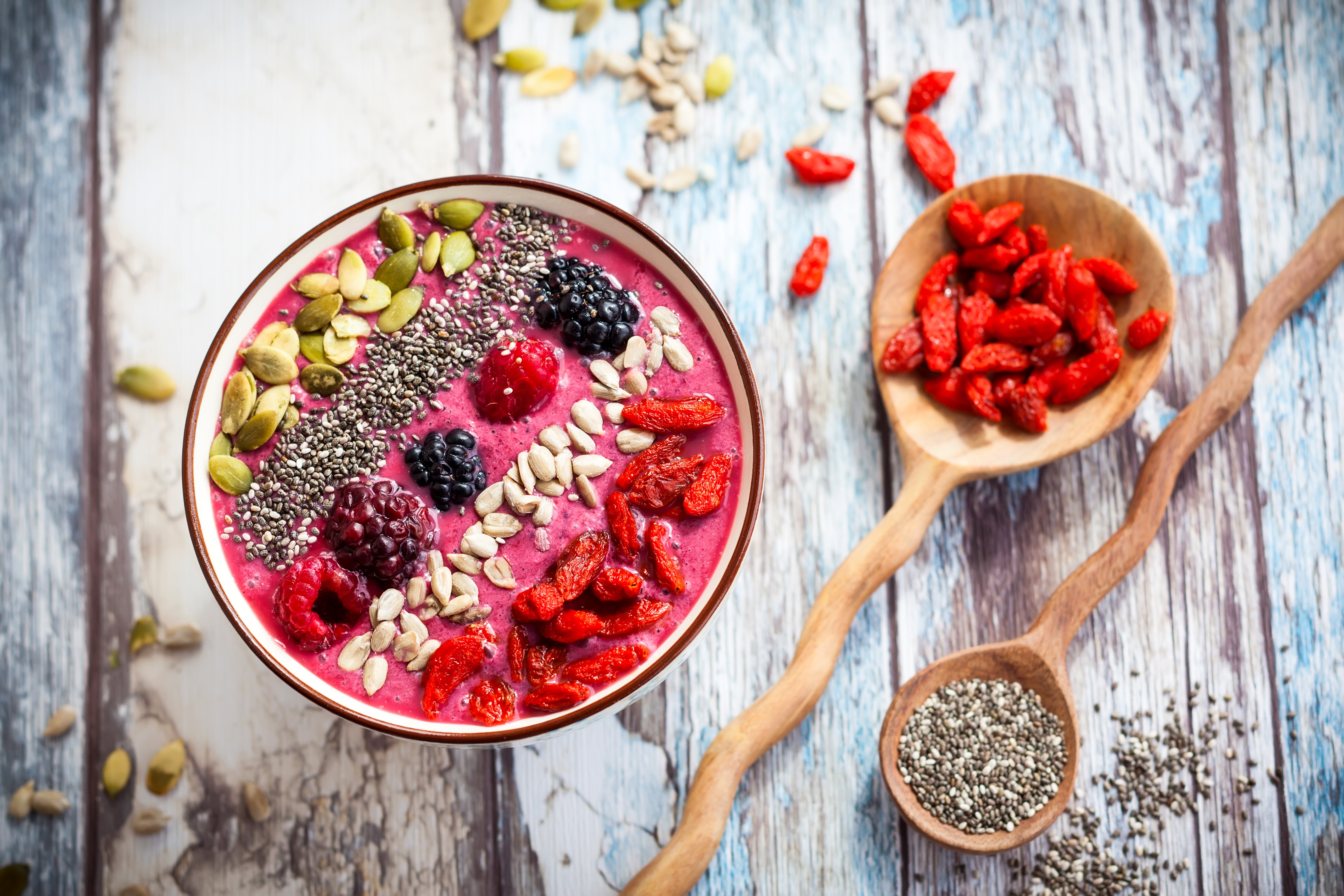 Smoothie bowl with berries and seeds on wood planks HD Wallpaper