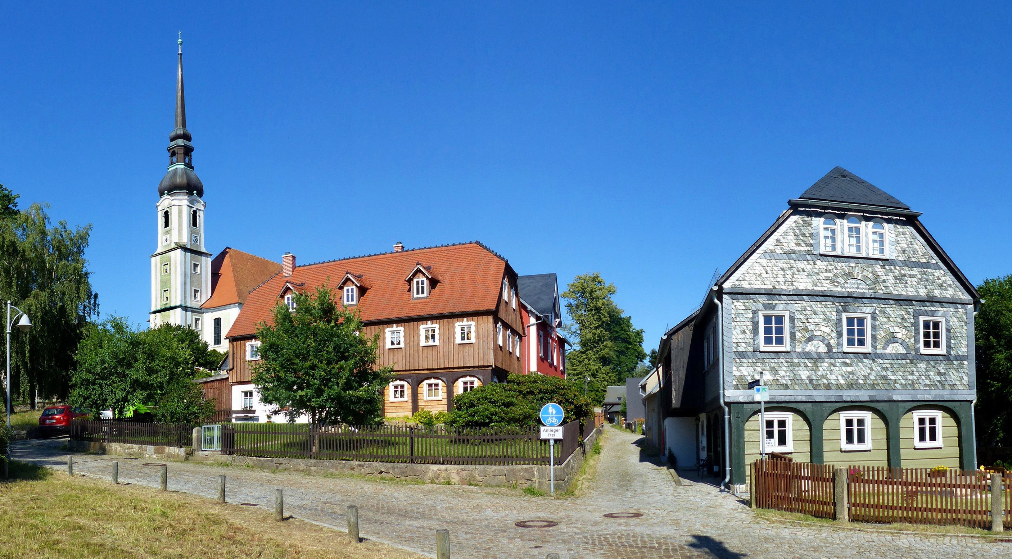 Church and houses on a cobblestone street in Germany HD Wallpaper