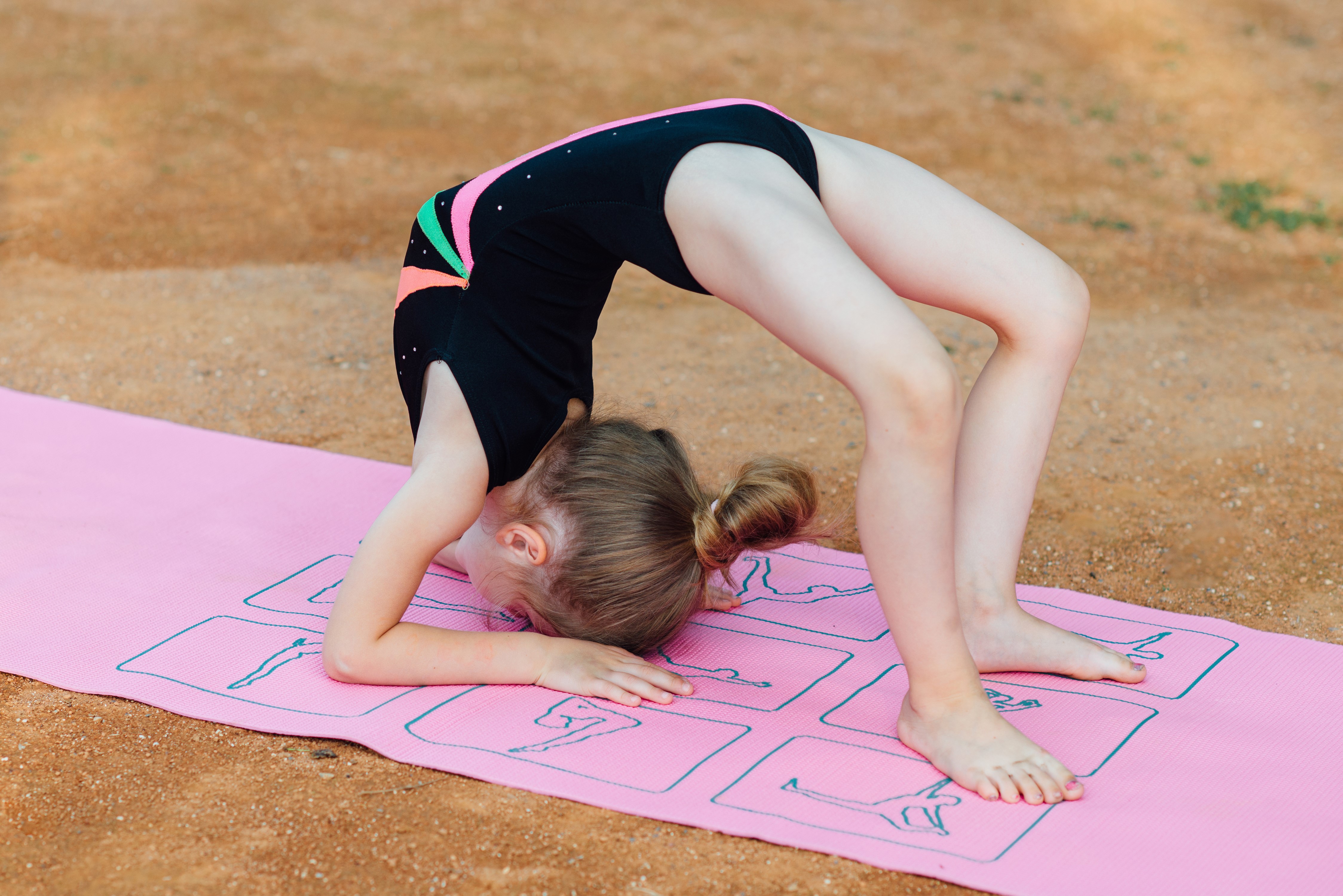 Young Girl Performing Gymnastics Stretch on Mat HD Wallpaper