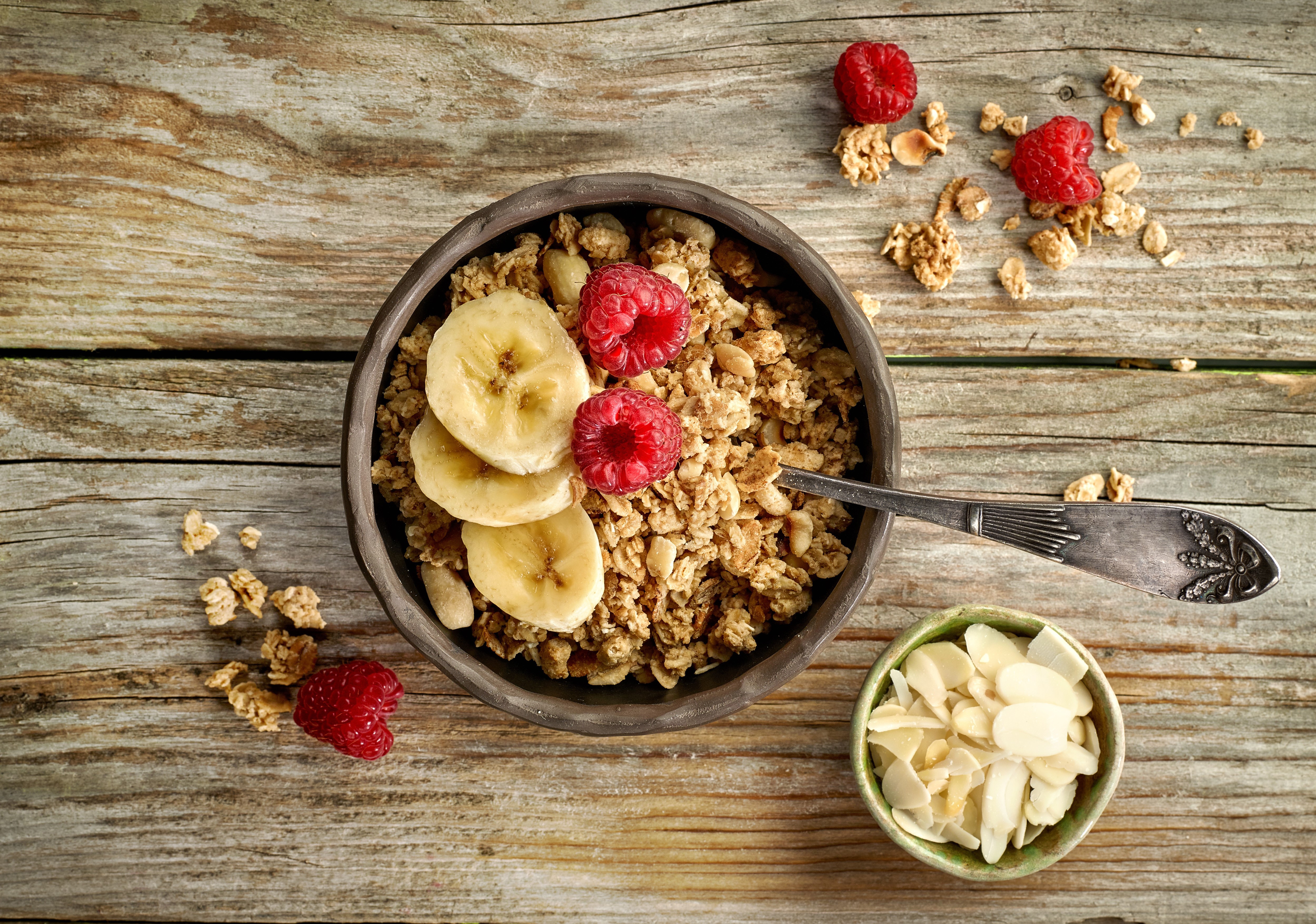 Granola with bananas and raspberries in a bowl HD Wallpaper
