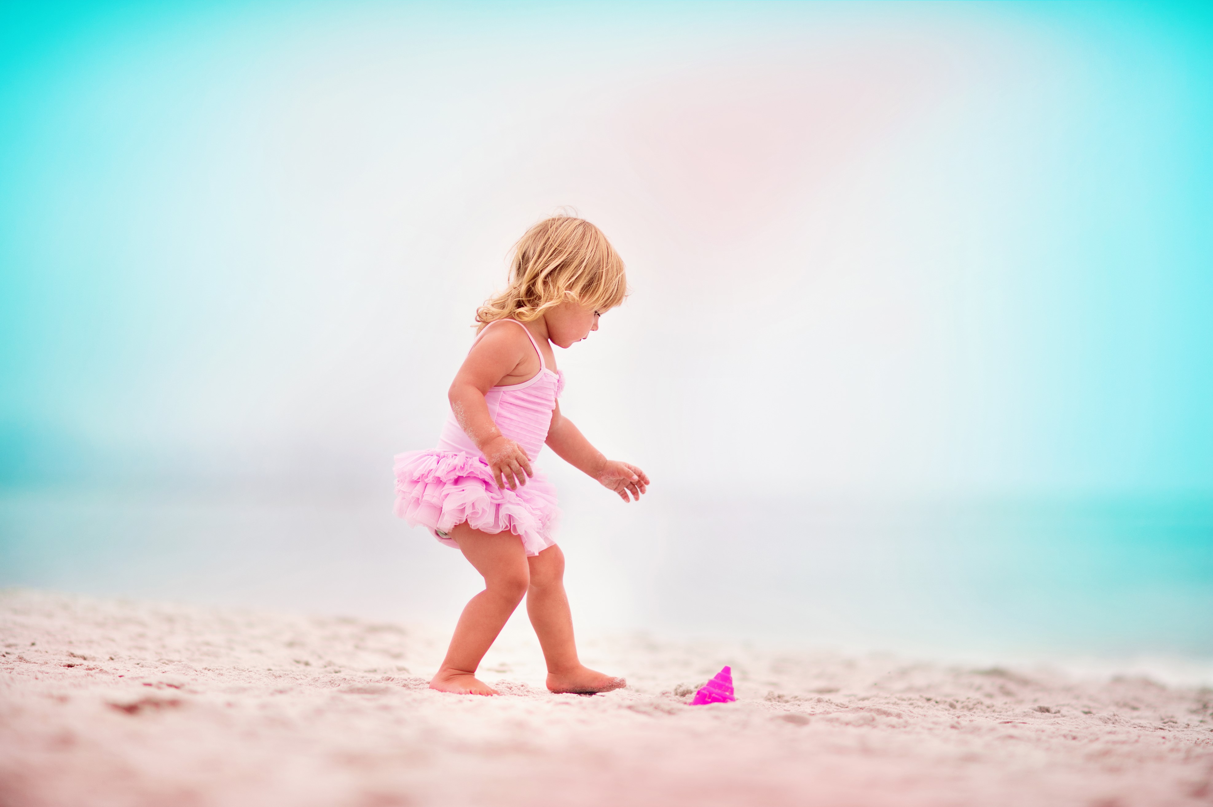Little girl in pink swimsuit on a beach HD Wallpaper