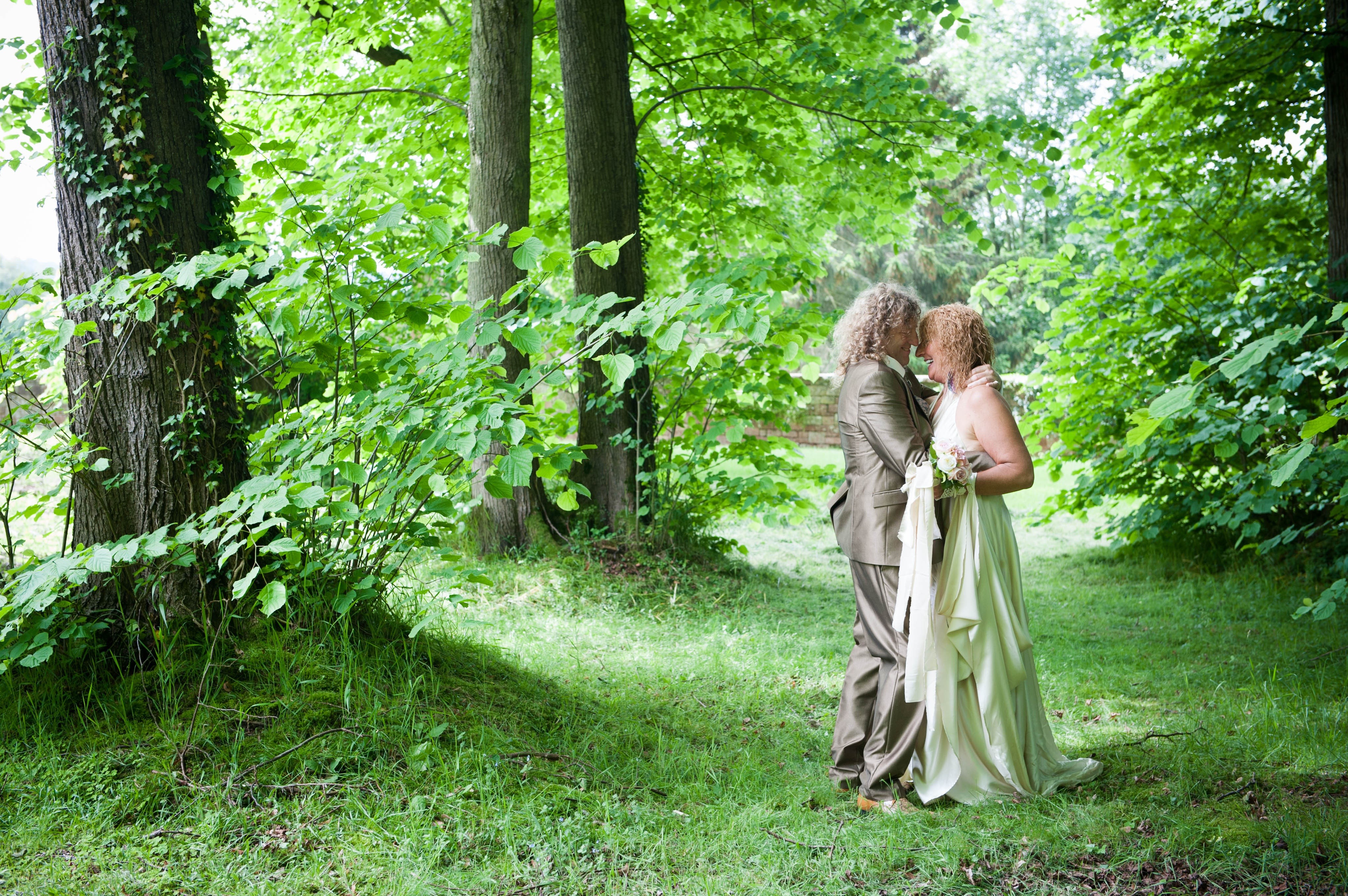 Couple in wedding attire in a forest HD Wallpaper