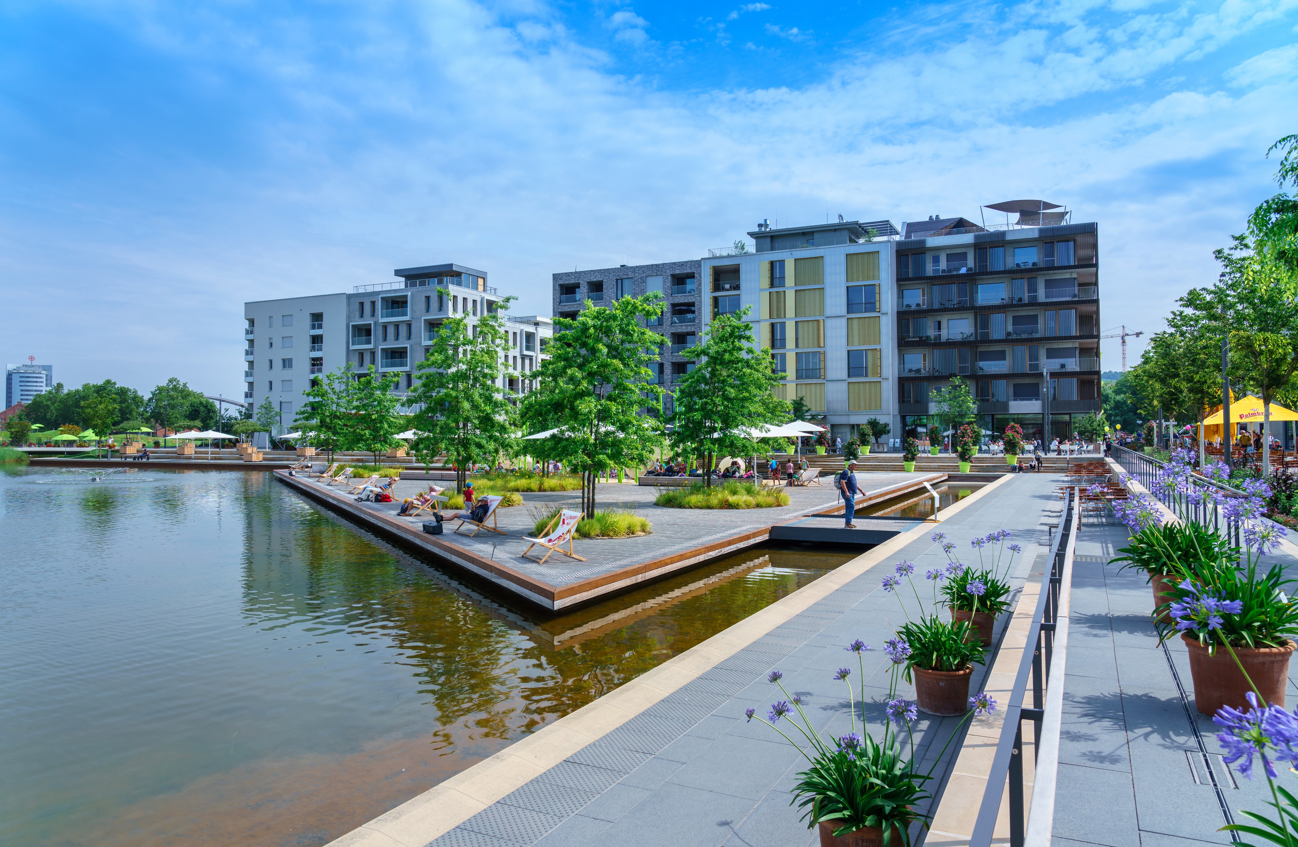 Modern apartment buildings and park with pond in Heilbronn, Germany HD Wallpaper