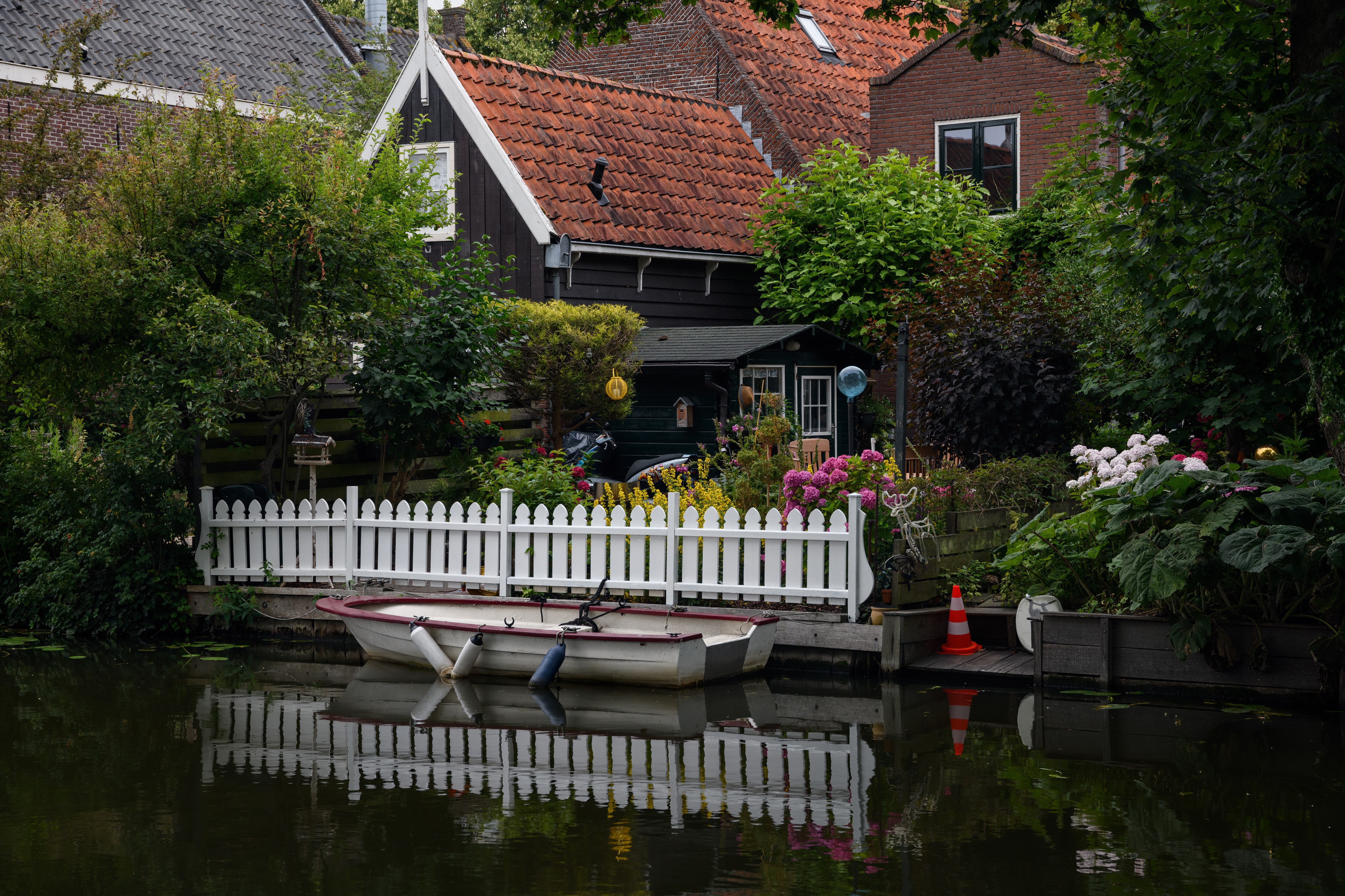 Boat docked by a white fence in Edam, Netherlands HD Wallpaper