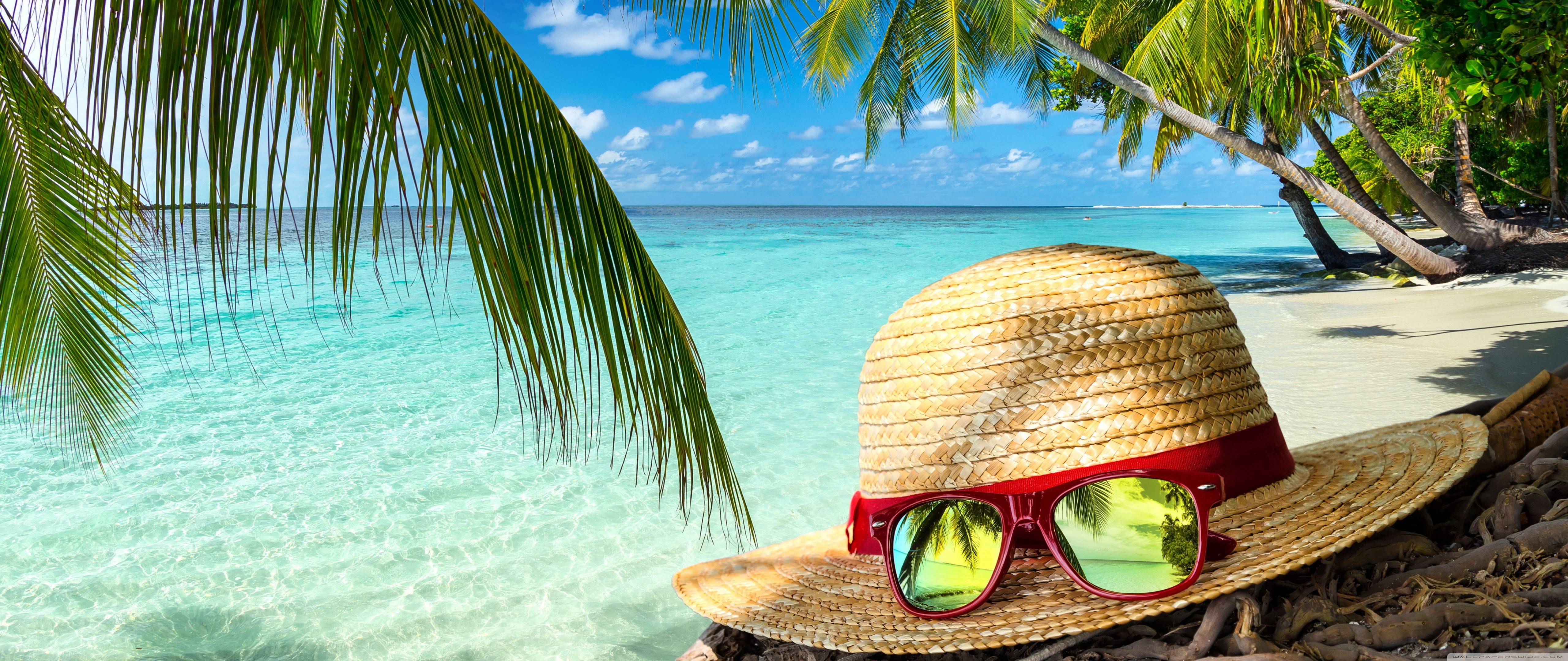 Straw hat and sunglasses on a tropical beach HD Wallpaper