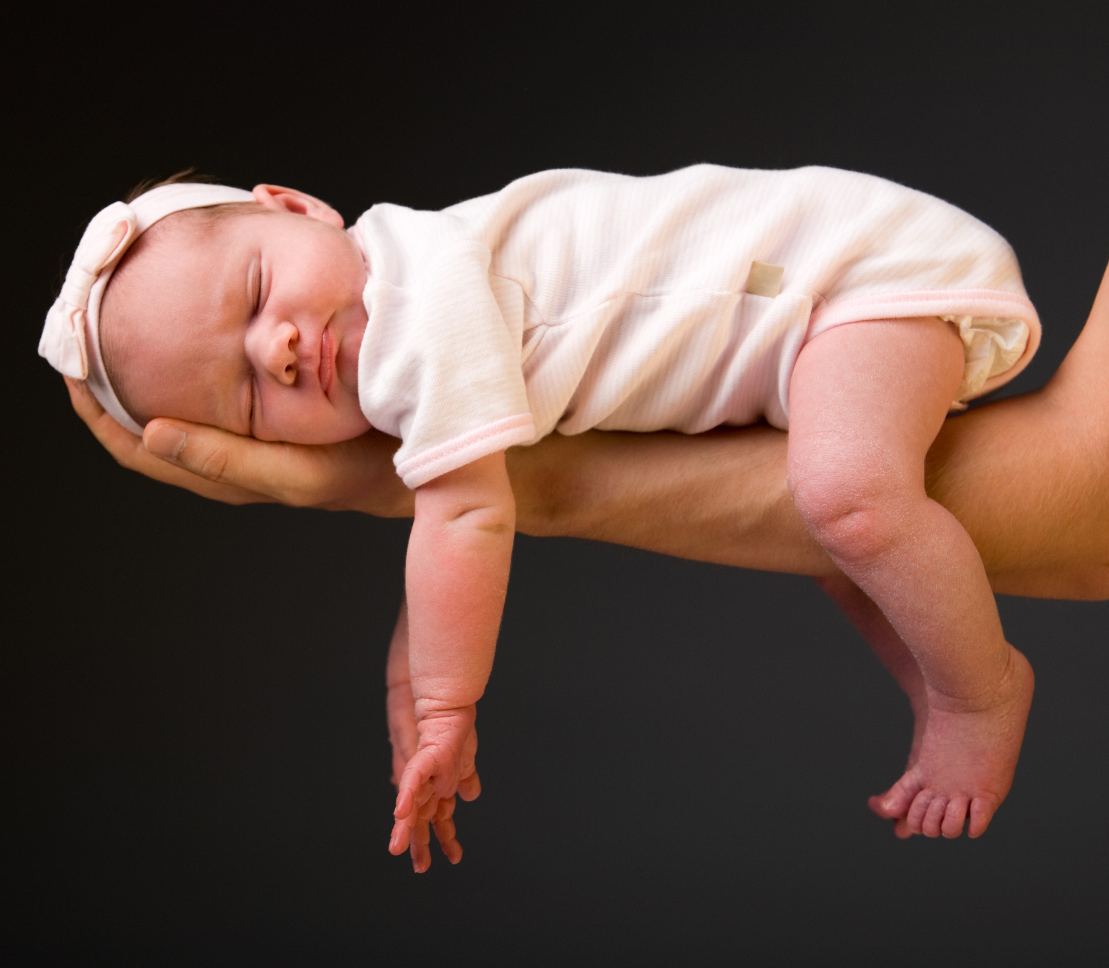 Newborn baby sleeping on a person's arm HD Wallpaper