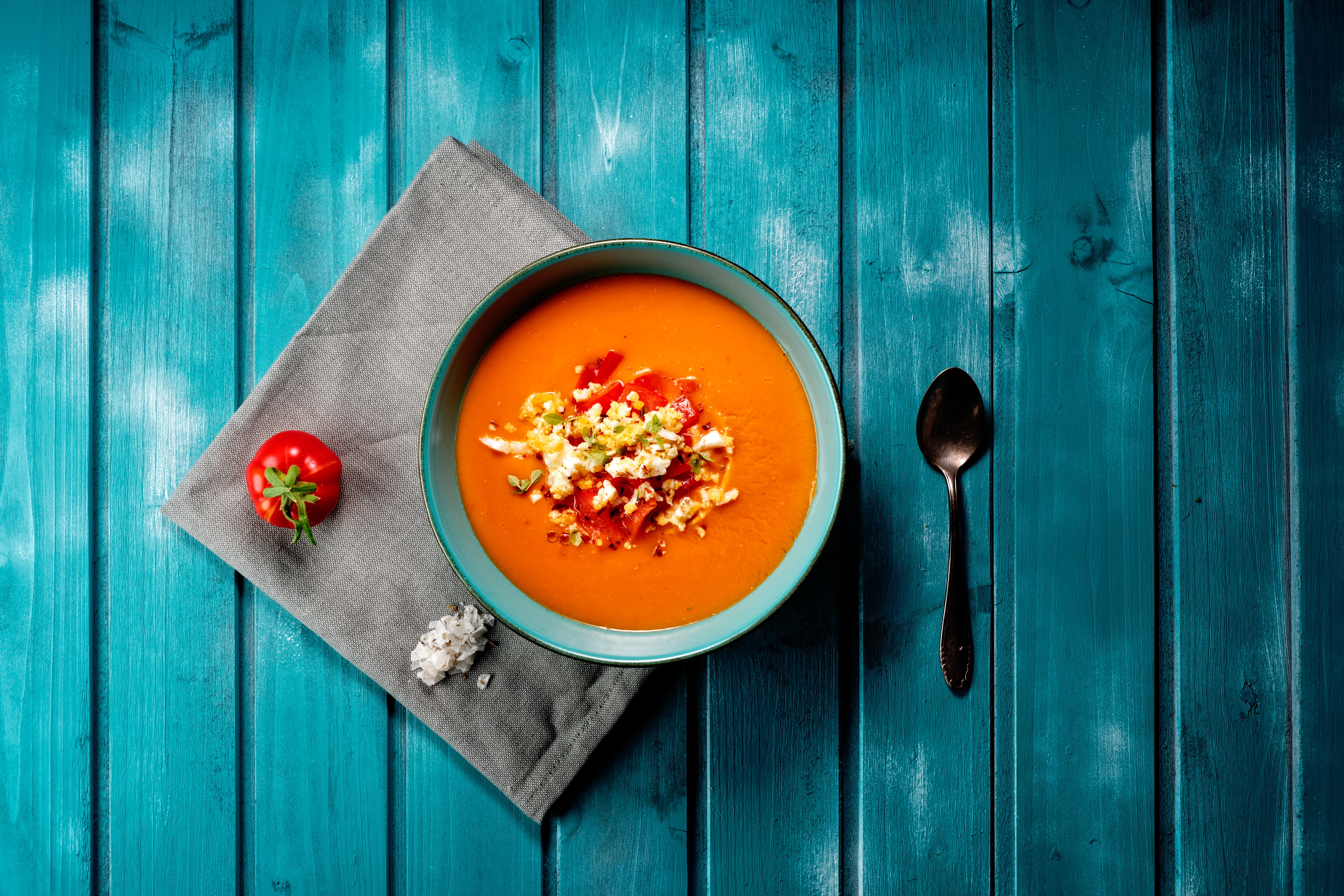 Gazpacho soup with tomato and egg garnish on blue wood HD Wallpaper