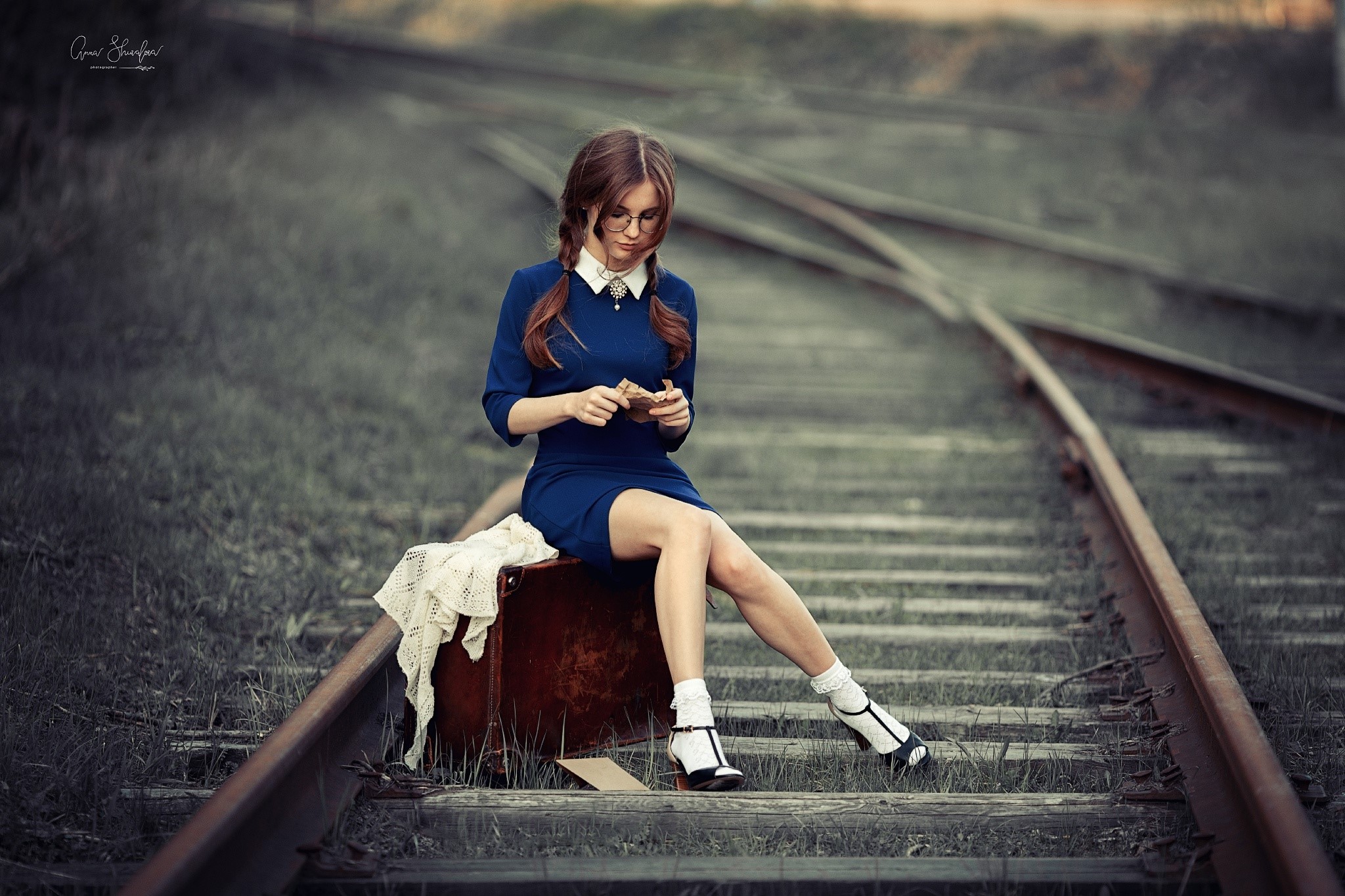 Anna Shuvalova sitting on a suitcase on railroad tracks HD Wallpaper