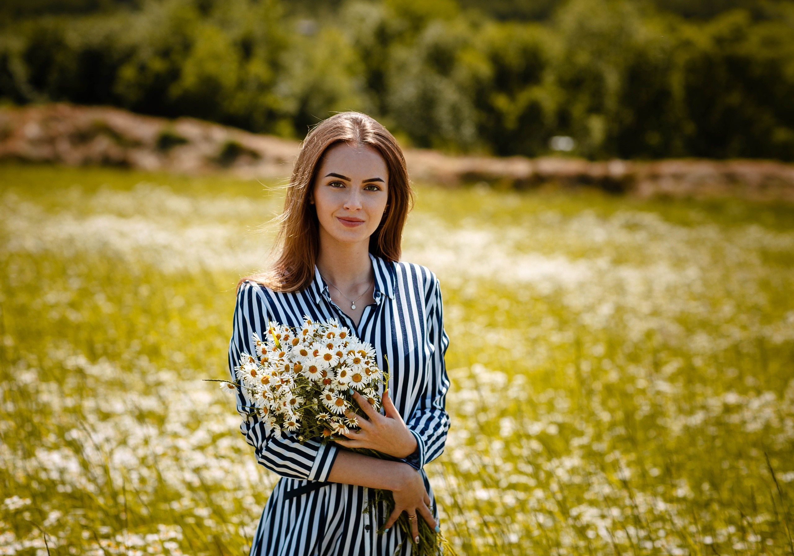 Woman holding a bouquet of camomiles in a field HD Wallpaper