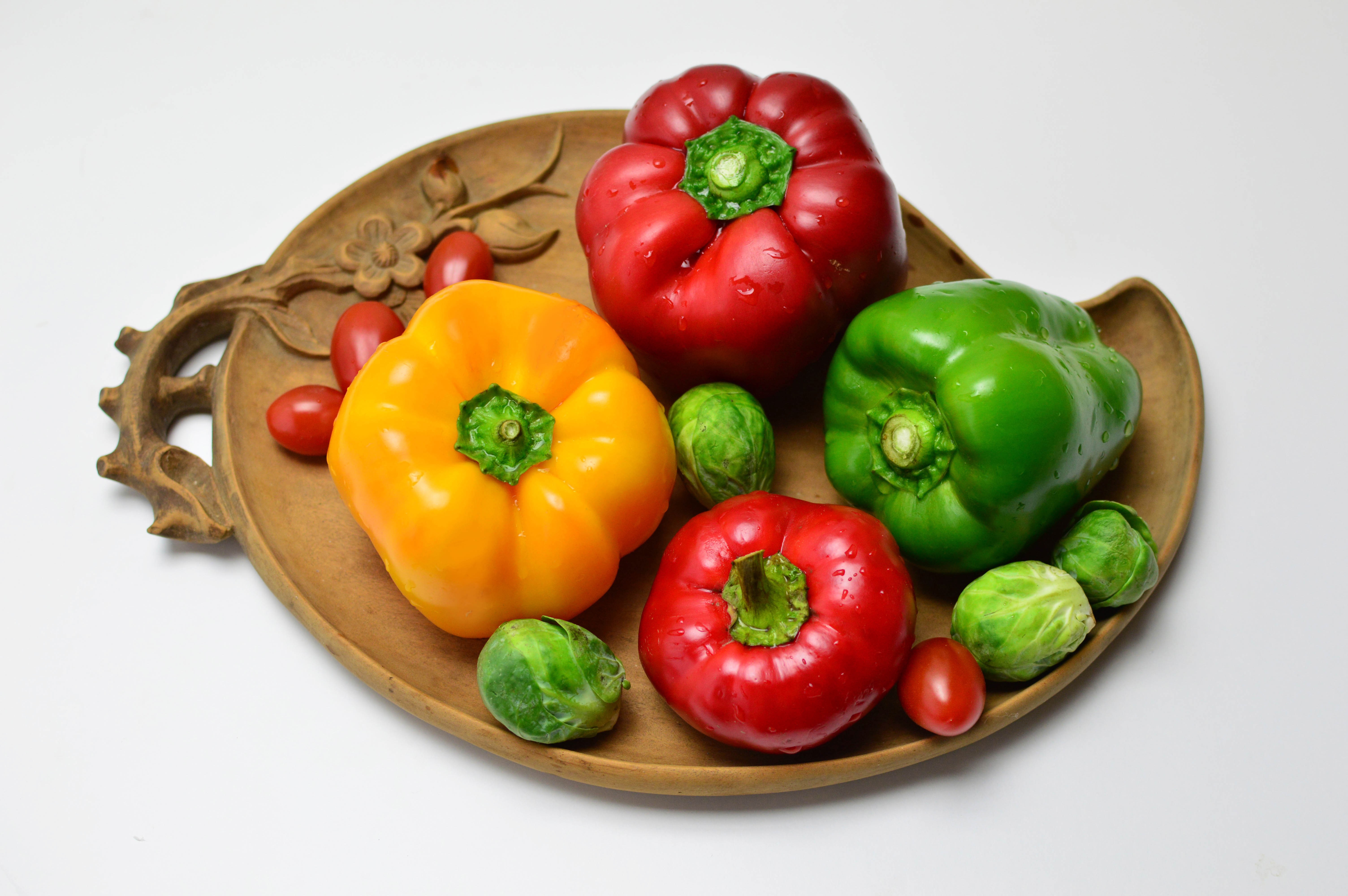 Bell peppers, tomatoes, and Brussels sprouts on a wooden tray HD Wallpaper