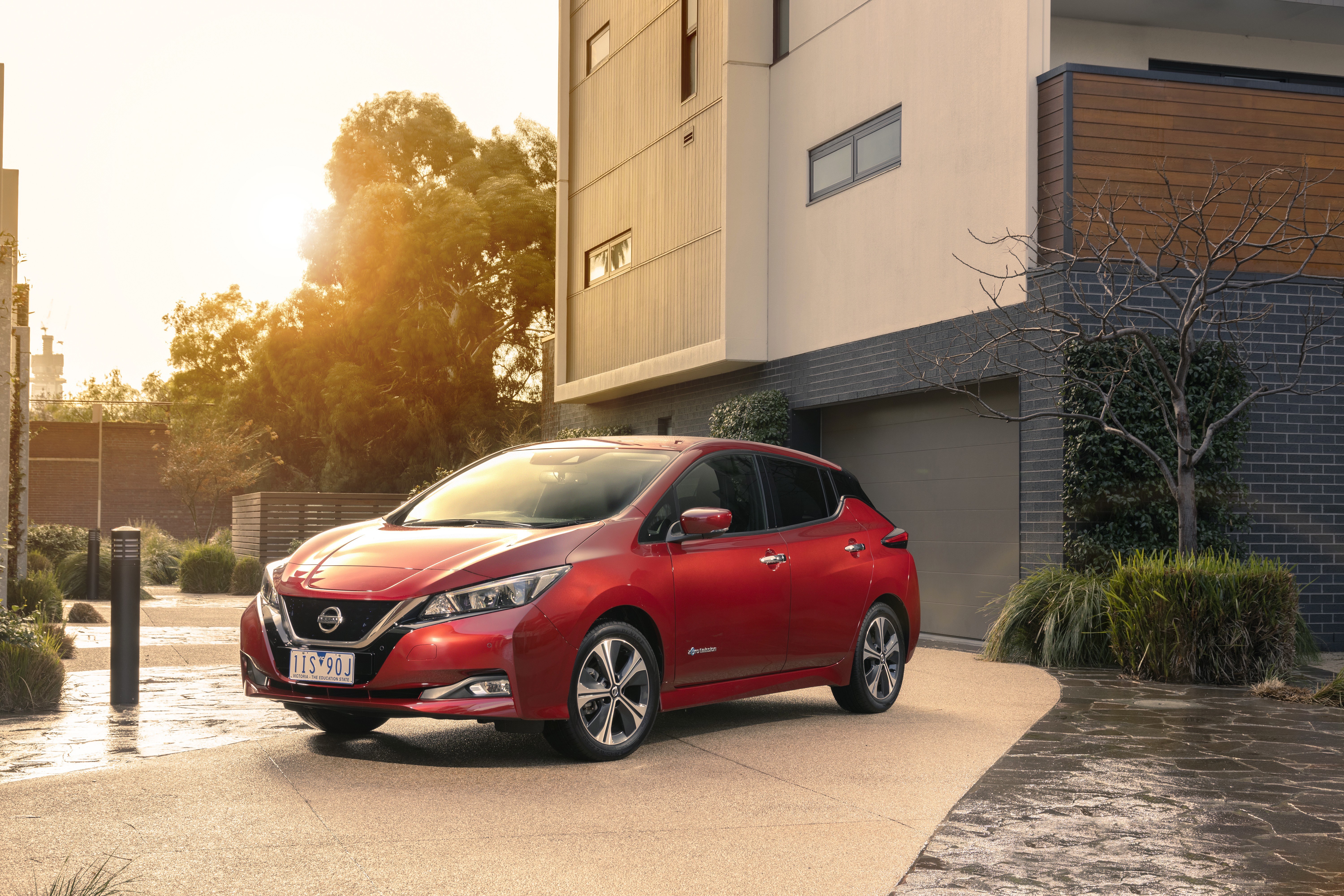 Red 2018-19 Nissan Leaf parked in driveway HD Wallpaper