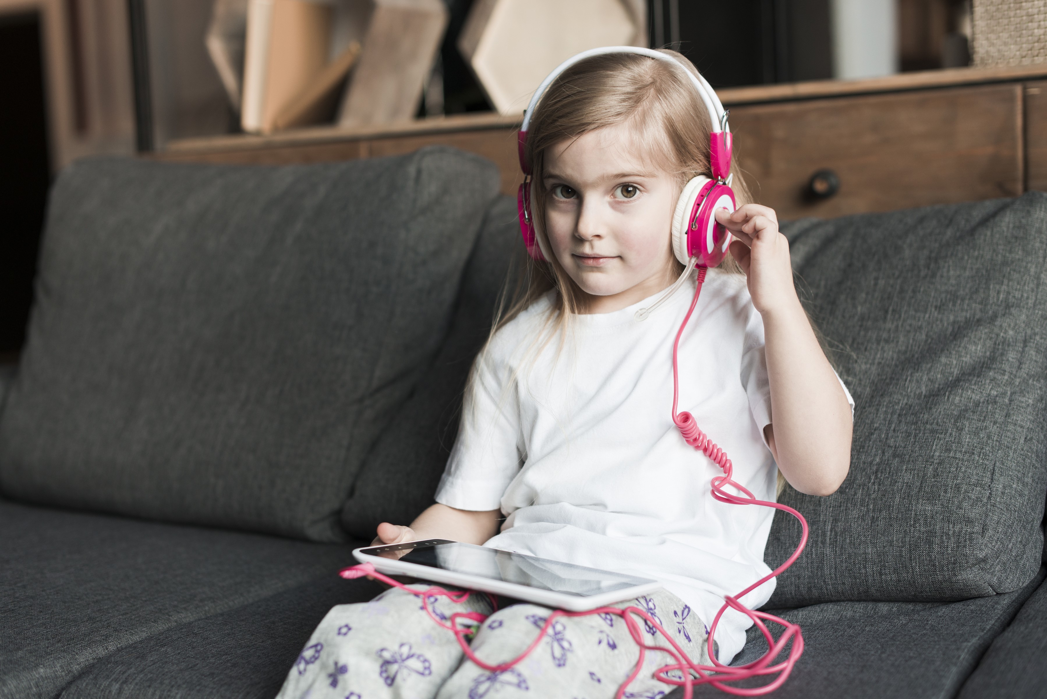 Girl with headphones and tablet on couch HD Wallpaper