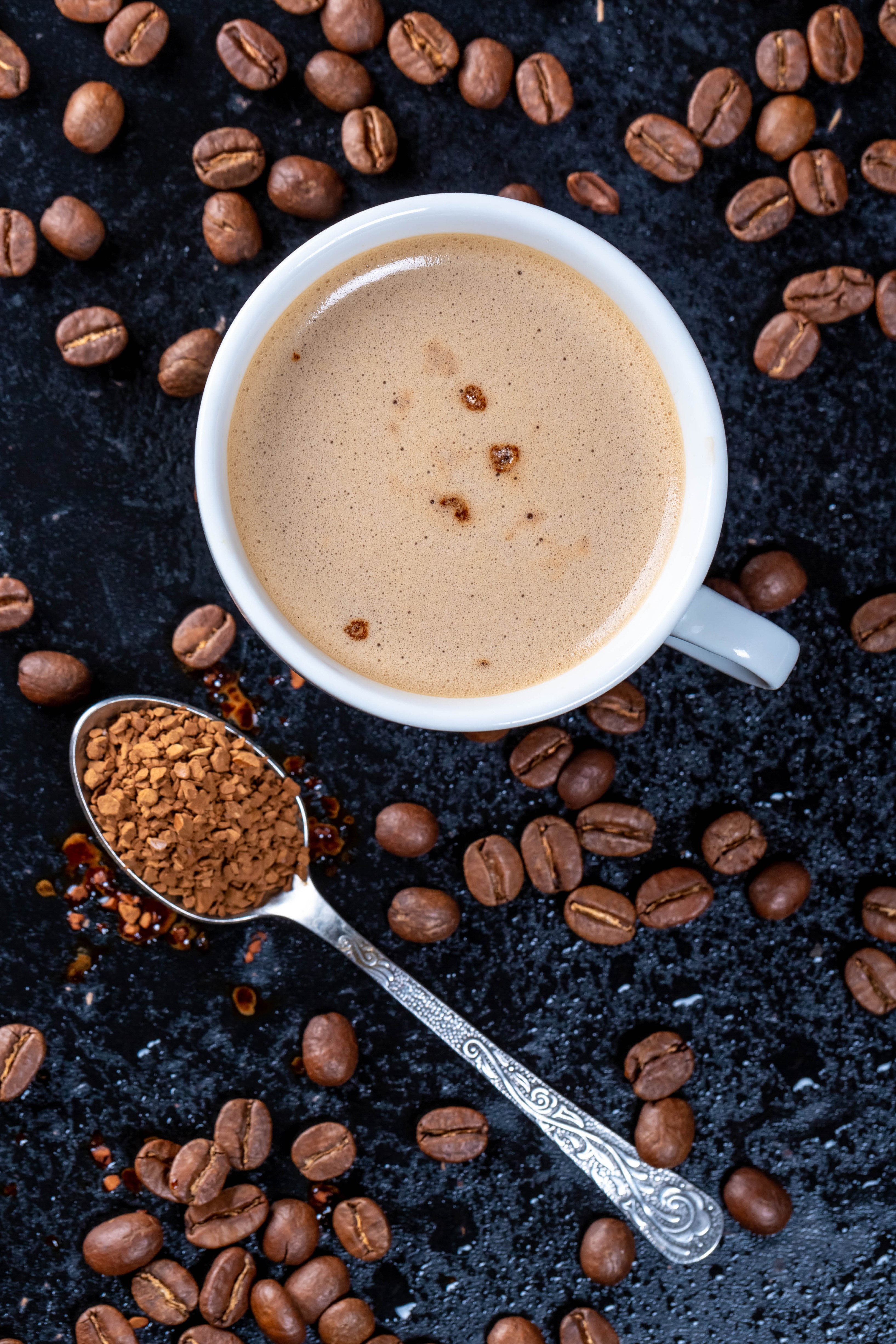 Cup of coffee with coffee beans and instant coffee on a spoon HD Phone Wallpaper