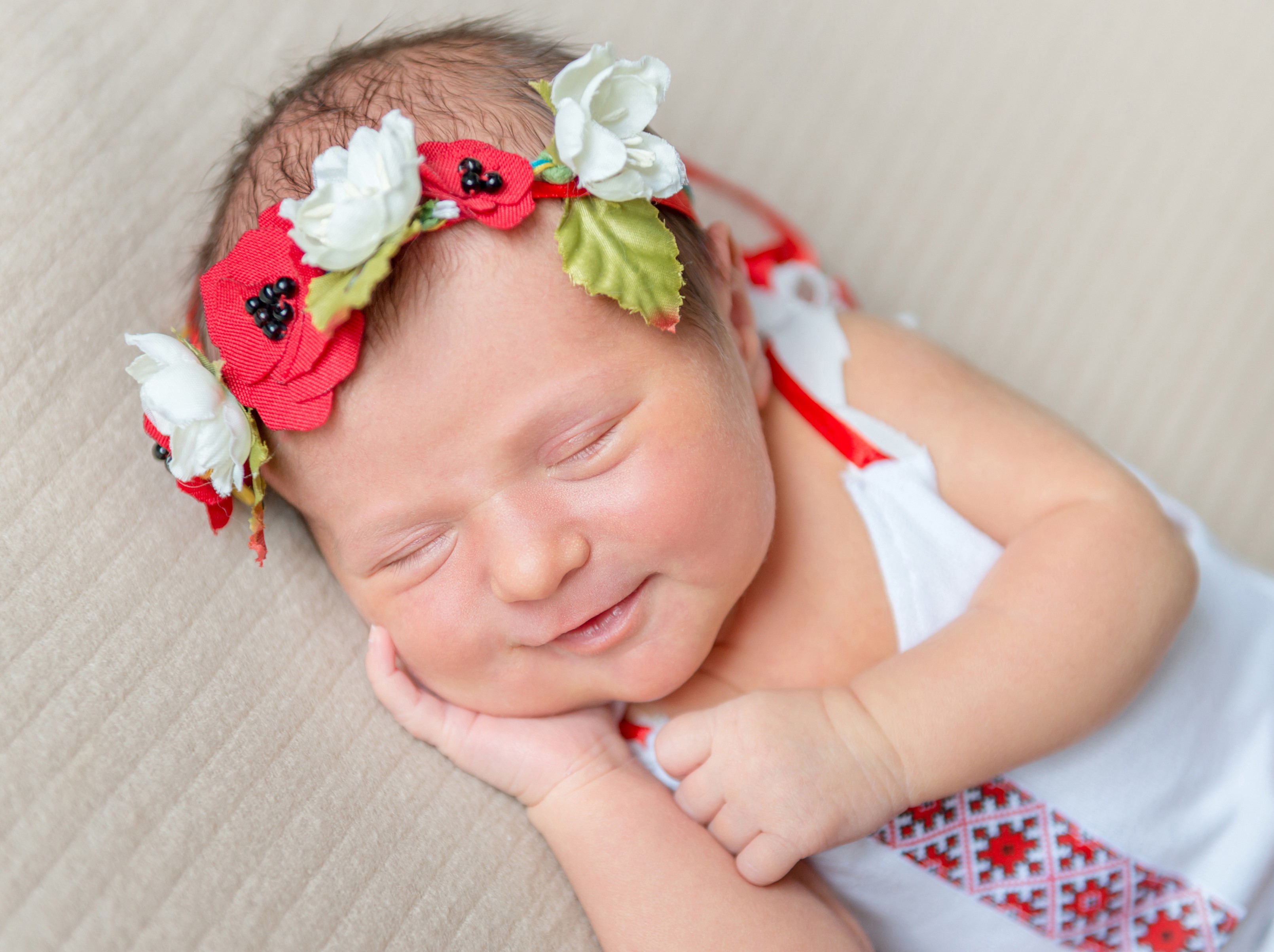 Newborn baby wearing a floral wreath and traditional clothing HD Wallpaper