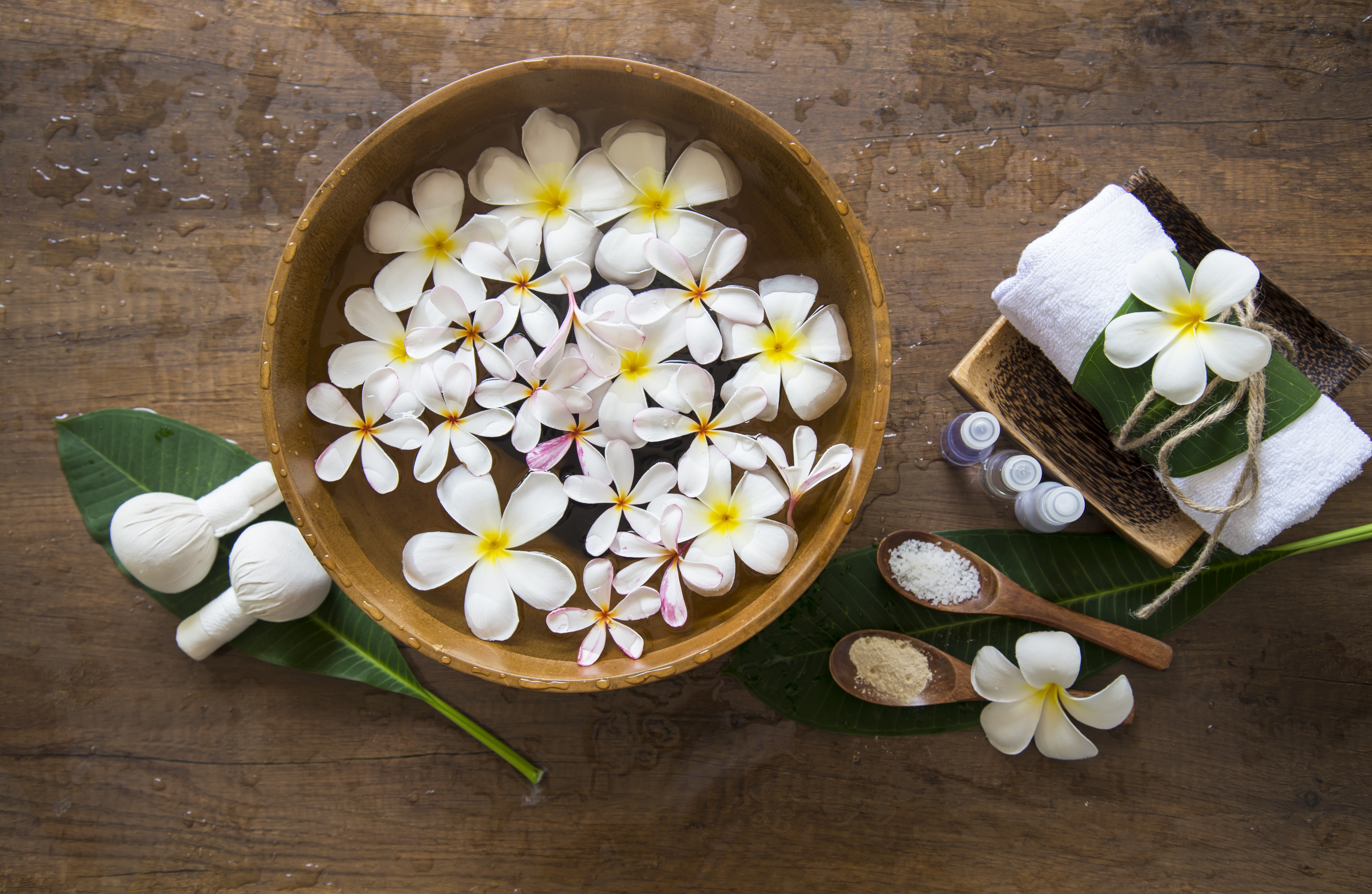 Spa setting with plumeria flowers, salt, and towels HD Wallpaper
