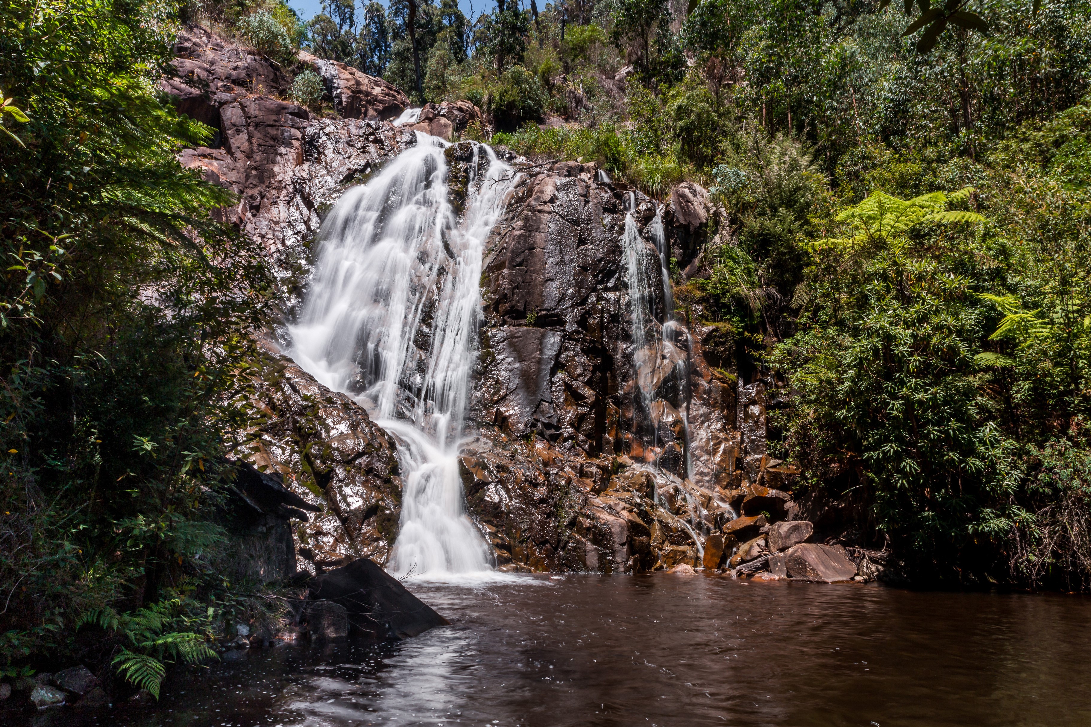 Waterfall cascading over rocks in a forest near Melbourne HD Wallpaper