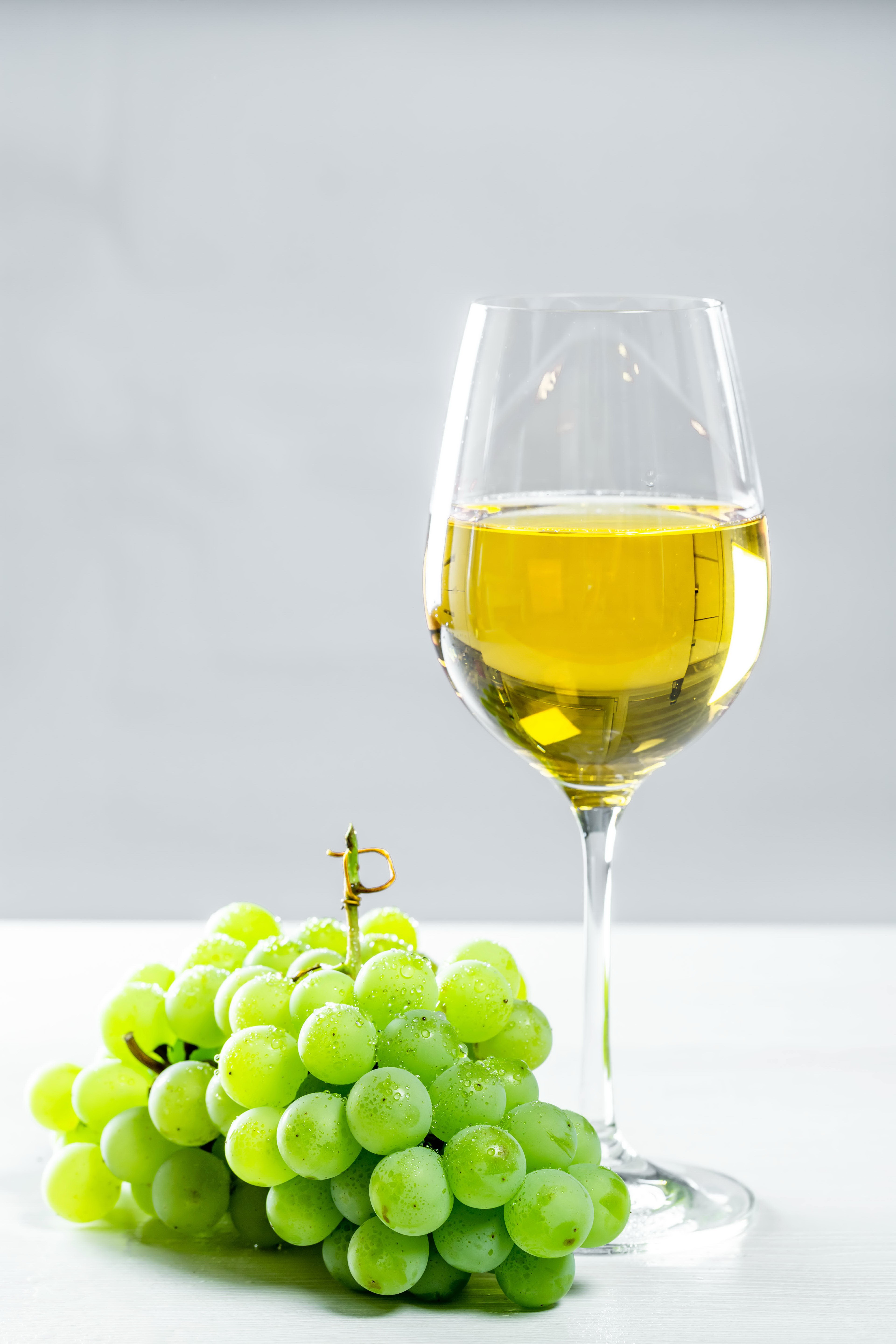 White wine in a glass with green grapes HD Phone Wallpaper